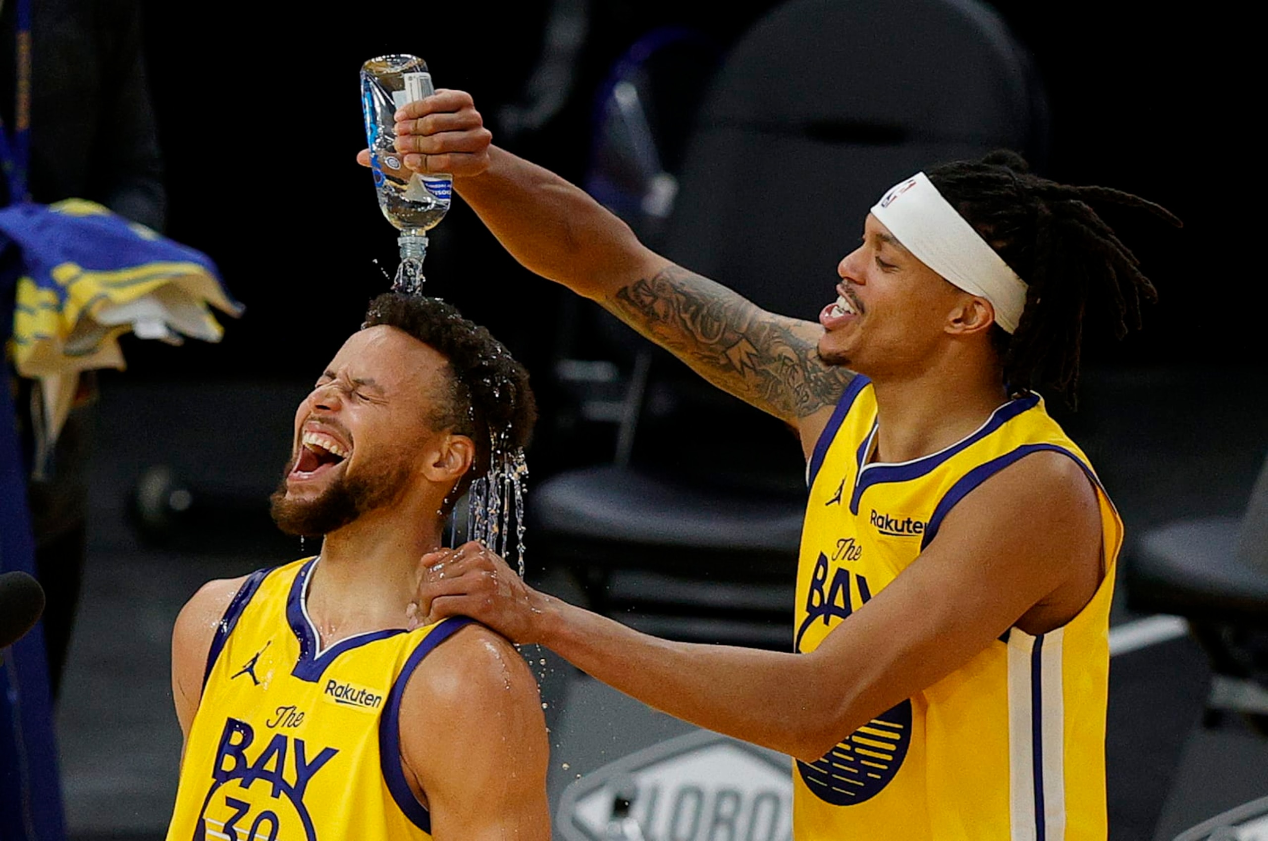SAN FRANCISCO, CALIFORNIA - JANUARY 03:  Stephen Curry #30 of the Golden State Warriors is showered in water by Damion Lee #1 of the Golden State Warriors during a post-game interview after Curry scored a career-high 62 points against the Portland Trail Blazers at Chase Center on January 03, 2021 in San Francisco, California. NOTE TO USER: User expressly acknowledges and agrees that, by downloading and or using this photograph, User is consenting to the terms and conditions of the Getty Images License Agreement.  (Photo by Ezra Shaw/undefined)