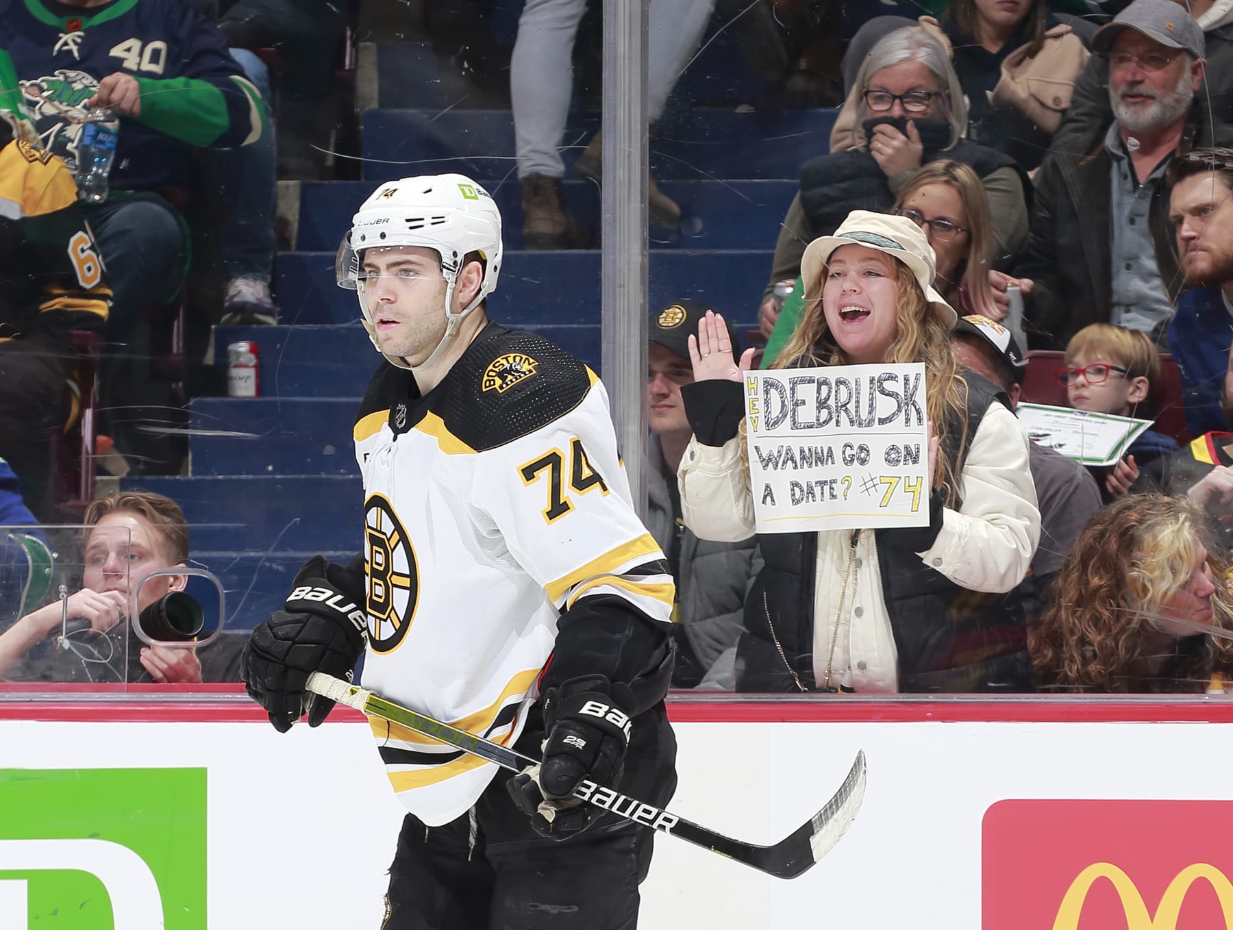 VANCOUVER, CANADA - FEBRUARY 25: Jake DeBrusk #74 of the Boston Bruins skates by fan holding up a date request during the second period of their NHL game against the Vancouver Canucks at Rogers Arena February 25, 2023 in Vancouver, British Columbia, Canada. (Photo by Jeff Vinnick/NHLI via Getty Images)