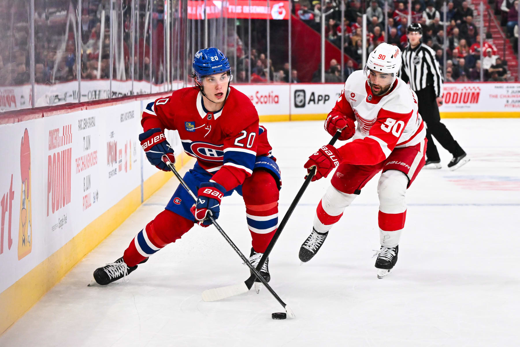 MONTREAL, CANADA - APRIL 16: Juraj Slafkovsky #20 of the Montreal Canadiens skates the puck against Joe Veleno #90 of the Detroit Red Wings during the second period at the Bell Centre on April 16, 2024 in Montreal, Quebec, Canada. (Photo by Minas Panagiotakis/Getty Images)