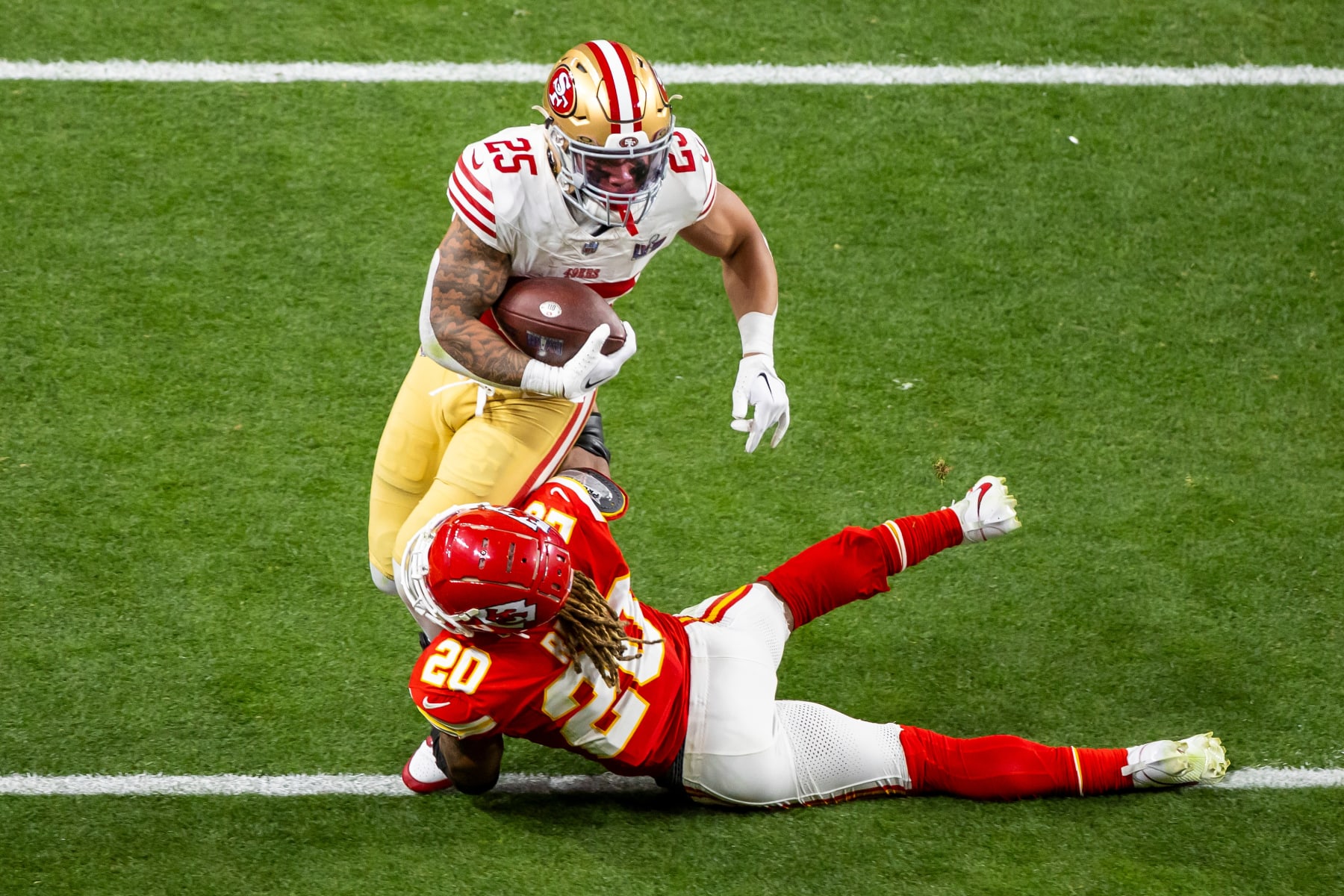 LAS VEGAS, NV - FEBRUARY 11: San Francisco 49ers running back Elijah Mitchell (25) attempts to run through the tackle of Kansas City Chiefs safety Justin Reid (20) during Super Bowl LVIII between the Kansas City Chiefs and the San Francisco 49ers on Sunday February 11, 2024 at Allegiant Stadium in Las Vegas, NV.  (Photo by Nick Tre. Smith/Icon Sportswire via Getty Images)