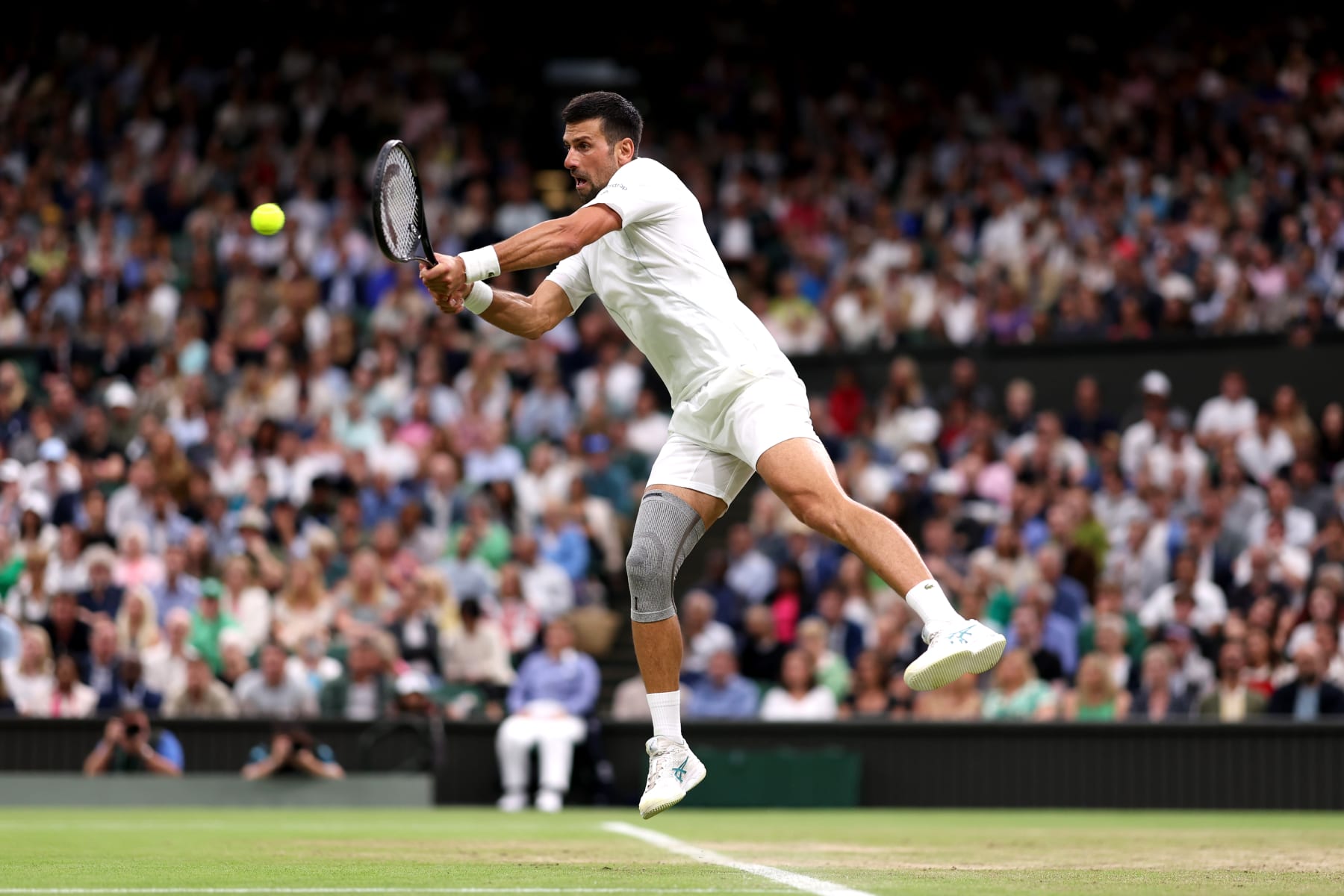 LONDON, ENGLAND - JULY 08: Novak Djokovic of Serbia plays a backhand against Holger Rune of Denmark in his Gentlemen's Singles fourth round match during day eight of The Championships Wimbledon 2024 at All England Lawn Tennis and Croquet Club on July 08, 2024 in London, England. (Photo by Julian Finney/Getty Images)