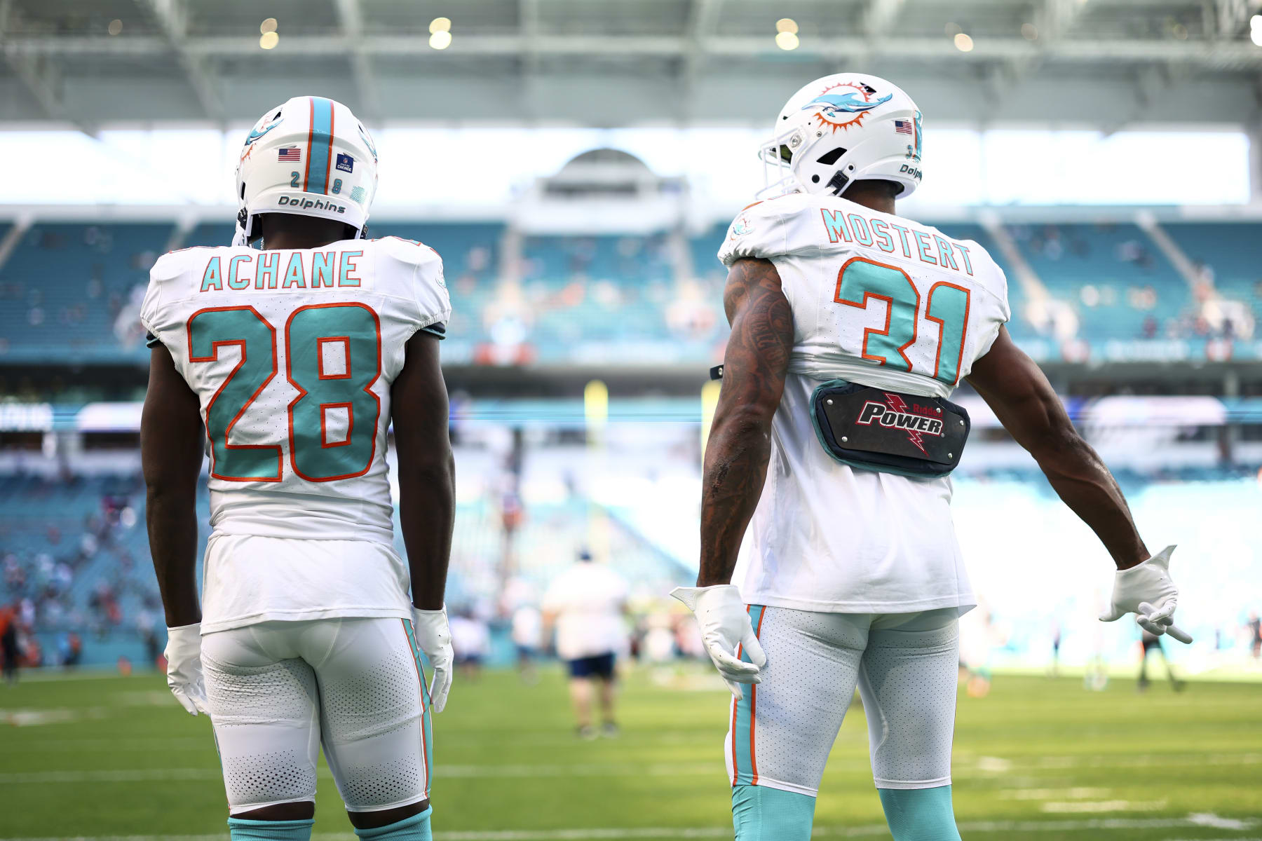 MIAMI GARDENS, FL - DECEMBER 17: De'Von Achane #28 and Raheem Mostert #31 of the Miami Dolphins warm up prior to an NFL football game against the New York Jets at Hard Rock Stadium on December 17, 2023 in Miami Gardens, Florida. (Photo by Kevin Sabitus/Getty Images)