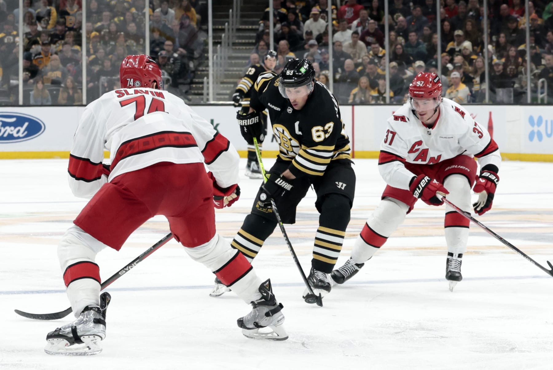 BOSTON, MA - APRIL 09: Boston Bruins left wing Brad Marchand (63) dishes the duck off during a game between the Boston Bruins and the Carolina Hurricanes on April 9, 2024, at TD Garden in Boston, Massachusetts. (Photo by Fred Kfoury III/Icon Sportswire via Getty Images)