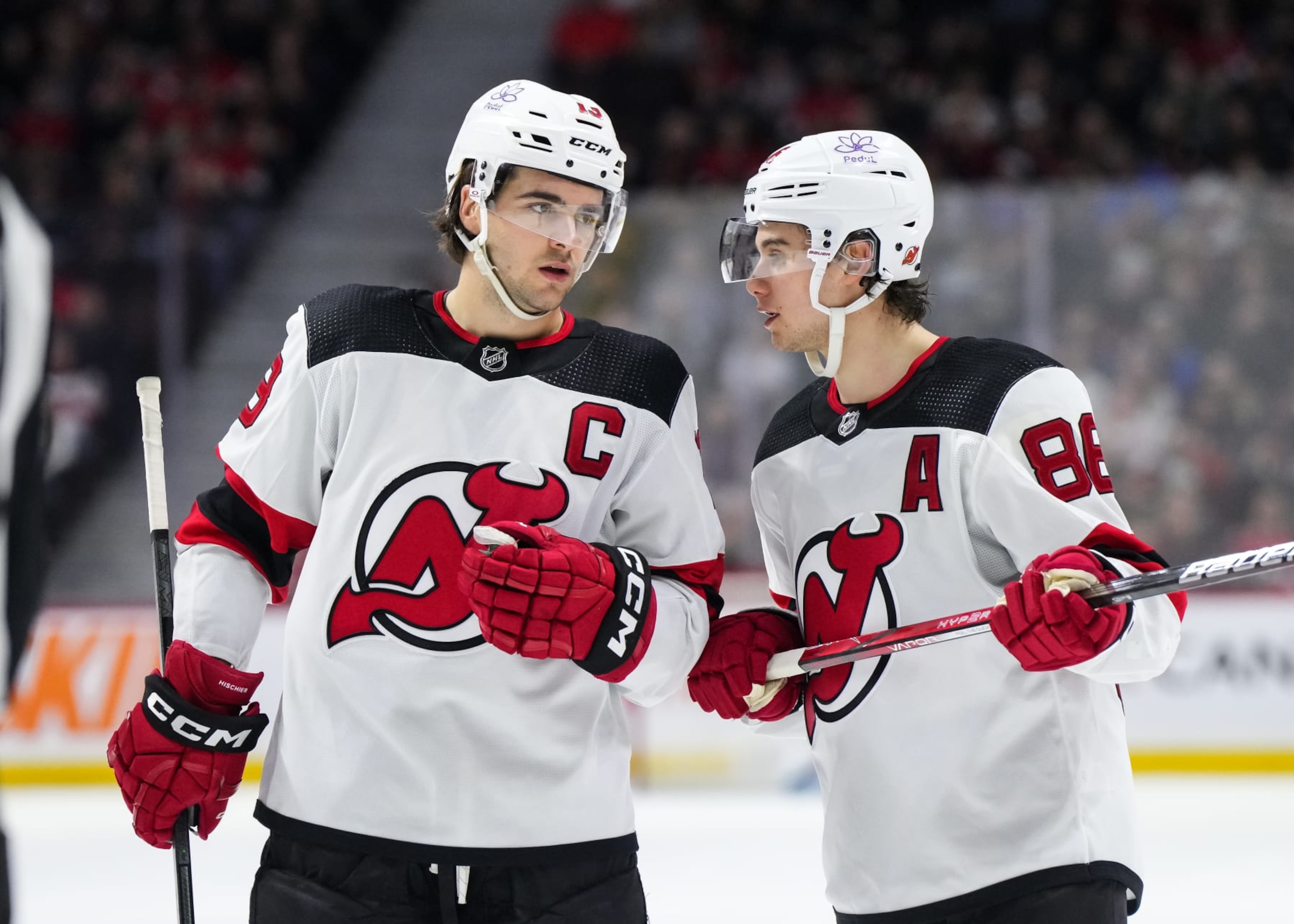 OTTAWA, CANADA - APRIL 6: Nico Hischier #13 of the New Jersey Devils talks with teammate Jack Hughes #86 in a game against the Ottawa Senators at Canadian Tire Centre on April 6, 2024 in Ottawa, Ontario, Canada. (Photo by Andrea Cardin/NHLI via Getty Images) OTTAWA, CANADA - APRIL 6: Nico Hischier #13 of the New Jersey Devils talks with teammate Jack Hughes #86 in a game against the Ottawa Senators at Canadian Tire Centre on April 6, 2024 in Ottawa, Ontario, Canada. (Photo by Andrea Cardin/NHLI via Getty Images)
