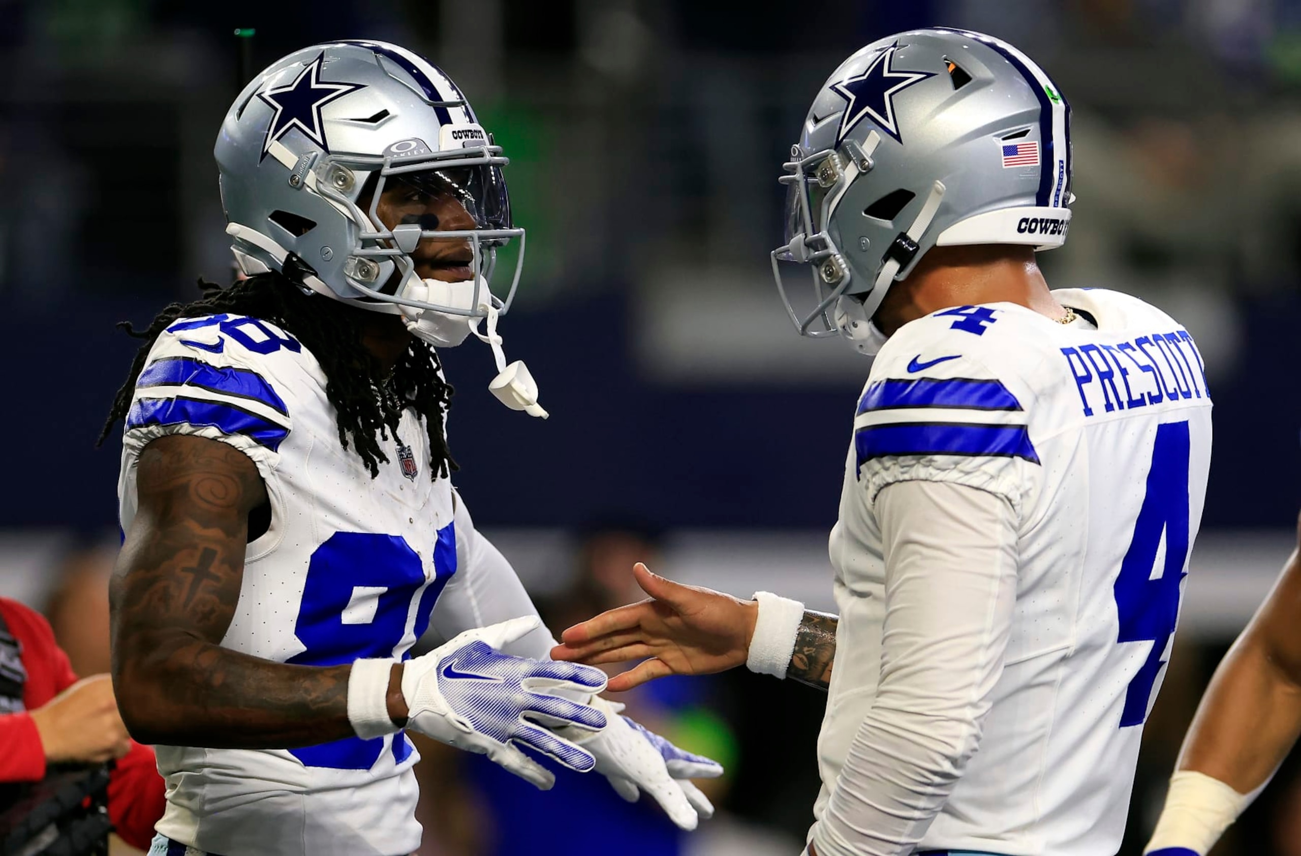 ARLINGTON, TEXAS - NOVEMBER 30:  Wide receiver CeeDee Lamb #88 of the Dallas Cowboys is congratulated by quarterback Dak Prescott #4 after catching a pass in the end zone for a touchdown during the 1st quarter of the game against the Seattle Seahawks at AT&T Stadium on November 30, 2023 in Arlington, Texas. (Photo by Ron Jenkins/Getty Images)
