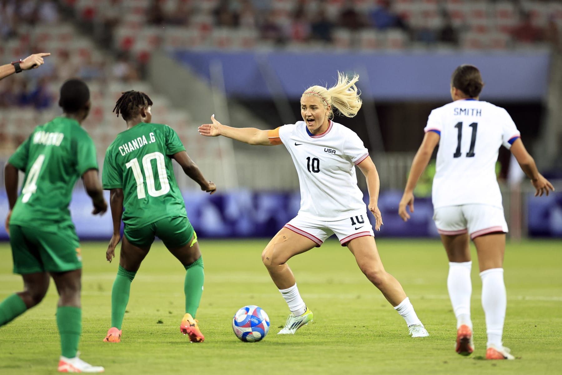 US' midfielder #10 Lindsey Horan is challenged by Zambia's midfielder #10 Grace Chanda in the women's group A football match between the USA and Zambia during the Paris 2024 Olympic Games at the Nice Stadium in Nice, on July 25, 2024. (Photo by Valery HACHE / AFP) (Photo by VALERY HACHE/AFP via Getty Images)