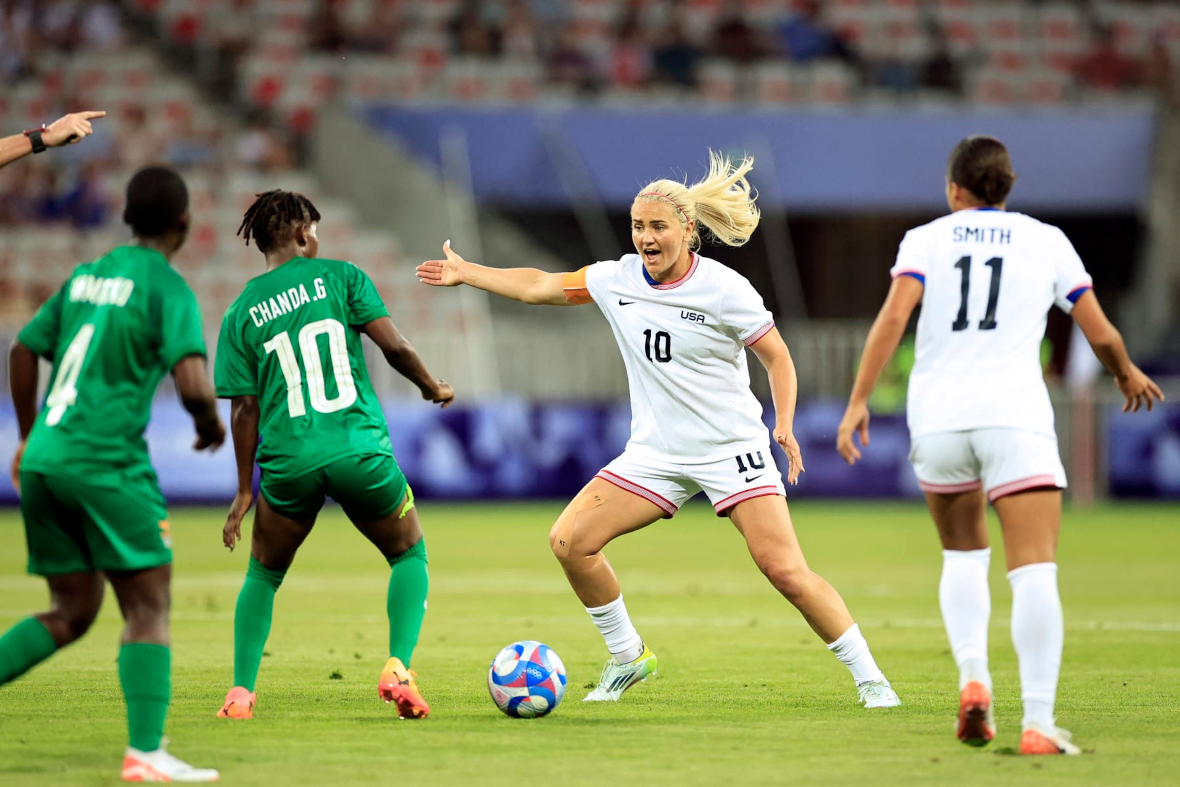 US' midfielder #10 Lindsey Horan is challenged by Zambia's midfielder #10 Grace Chanda in the women's group A football match between the USA and Zambia during the Paris 2024 Olympic Games at the Nice Stadium in Nice, on July 25, 2024. (Photo by Valery HACHE / AFP) (Photo by VALERY HACHE/AFP via Getty Images)