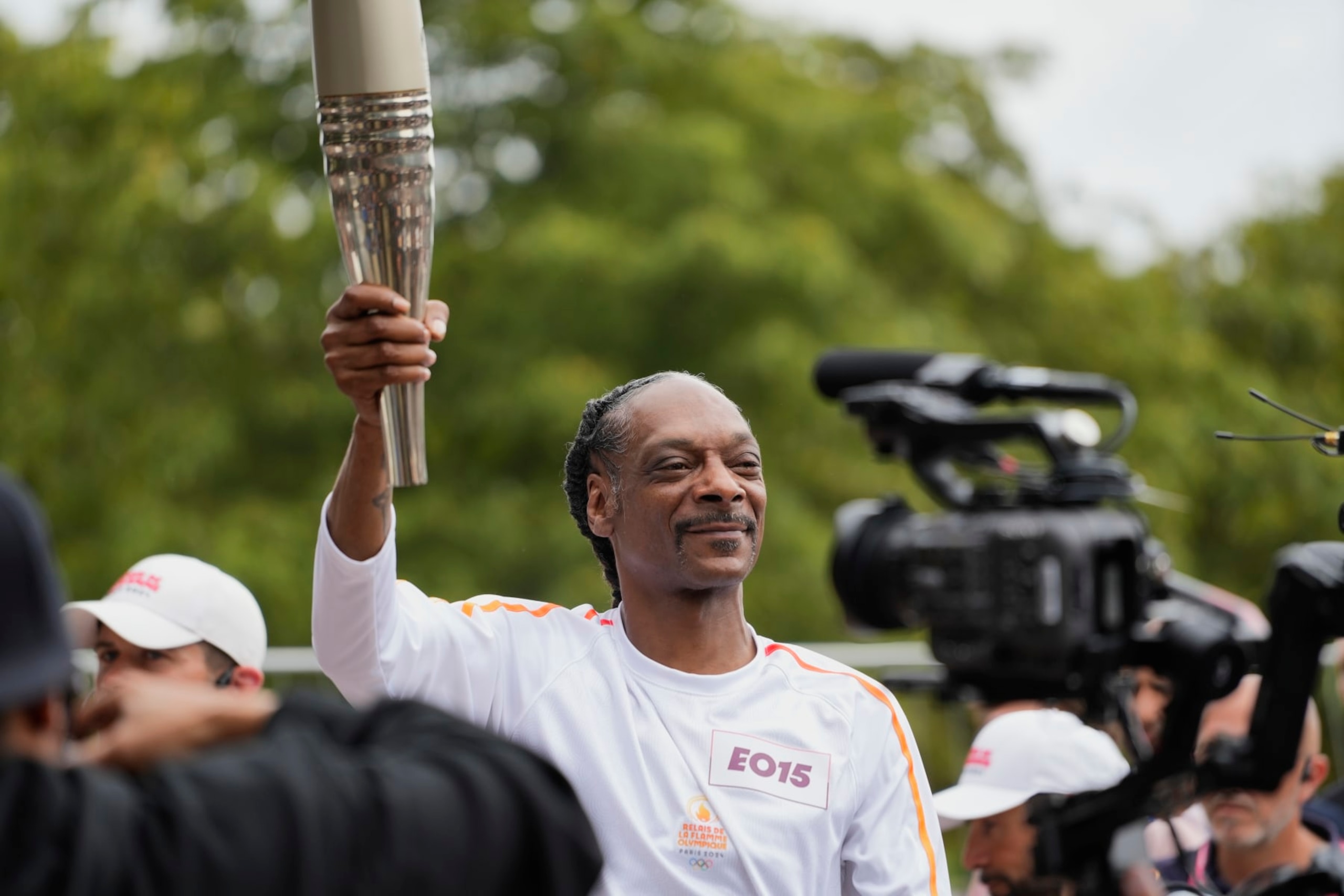 SAINT DENIS, SEINE-SAINT-DENIS, FRANCE - JULY 26: American rapper Snoop Dogg is seen carrying the Olympic flame during the torch relay ahead of the Summer Olympic Games Paris 2024 on July 26, 2024 in the Saint-Denis commune of Paris, France. (Photo by Remon Haazen/Getty Images)