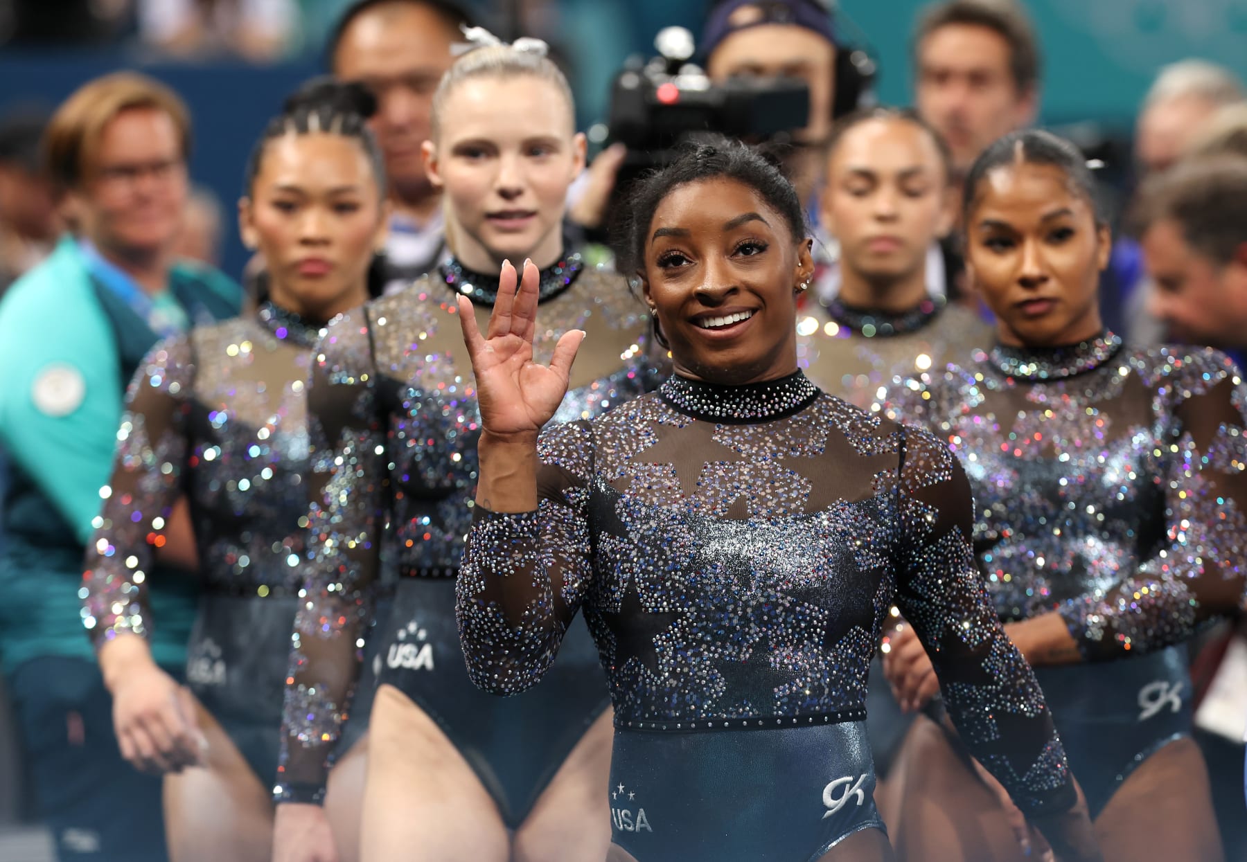 PARIS, FRANCE - JULY 28: Simone Biles of Team United States waves as she is joined by members of Team United States following Subdivision 2 during the Artistic Gymnastics Women's Qualification on day two of the Olympic Games Paris 2024 at Bercy Arena on July 28, 2024 in Paris, France. (Photo by Ezra Shaw/Getty Images)