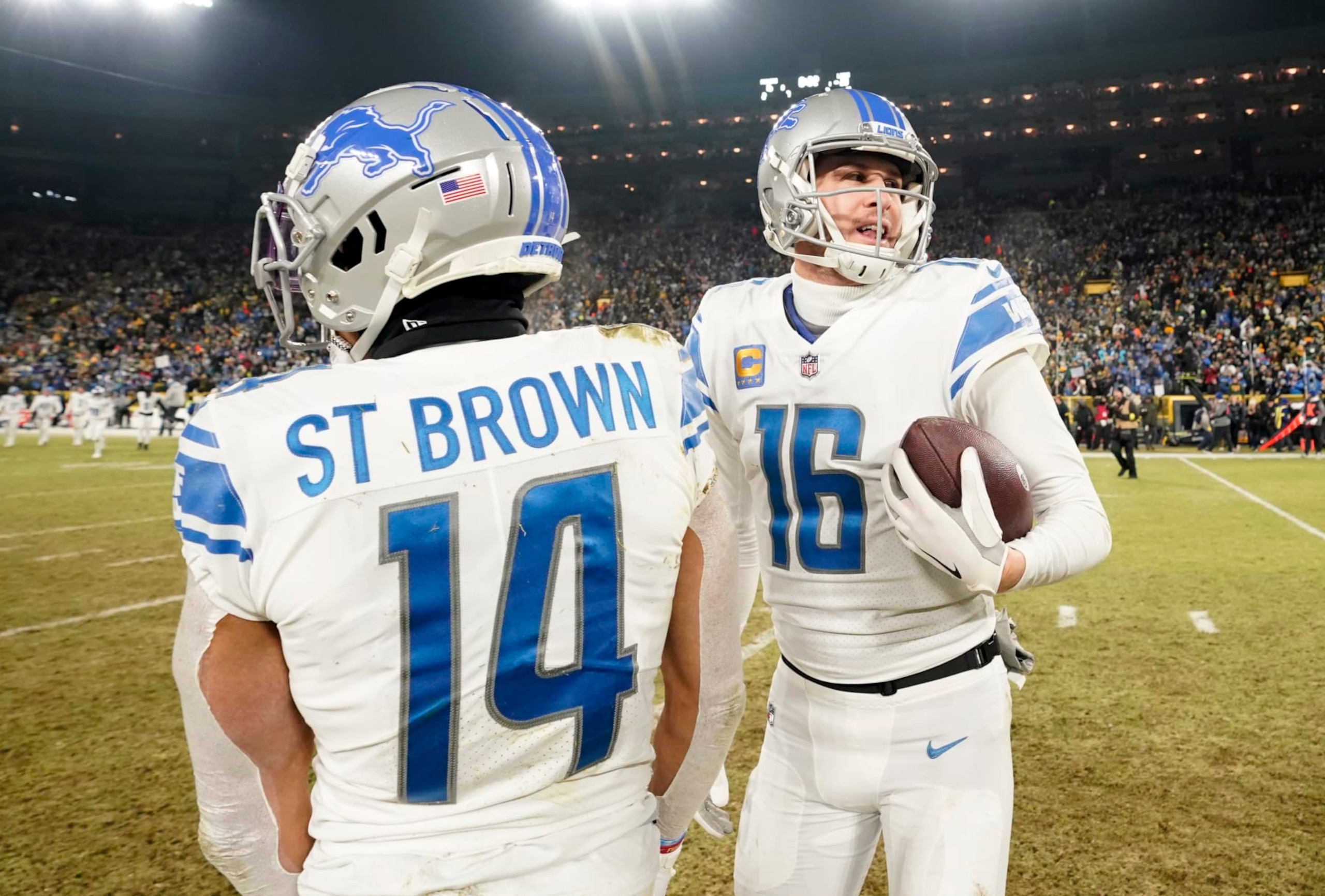GREEN BAY, WISCONSIN - JANUARY 08: Jared Goff #16 and Amon-Ra St. Brown #14 of the Detroit Lions react after defeating the Green Bay Packers at Lambeau Field on January 08, 2023 in Green Bay, Wisconsin. (Photo by Patrick McDermott/Getty Images)