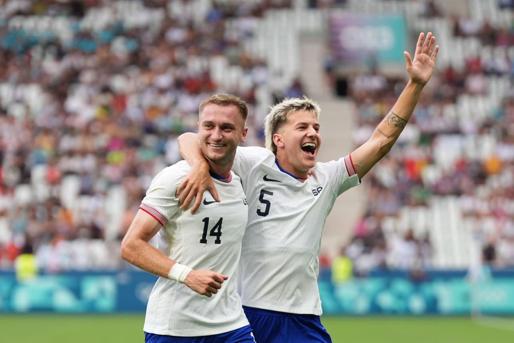SAINT-ETIENNE, FRANCE - JULY 30: Djordje Mihailovic #14 of the United States celebrates scoring with John Tolkin #5 during the first half against Guinea the Men's group A match during the Olympic Games Paris 2024 at Stade Geoffroy-Guichard on July 30, 2024 in Saint-Etienne, France. (Photo by Andrea Vilchez/ISI/Getty Images)