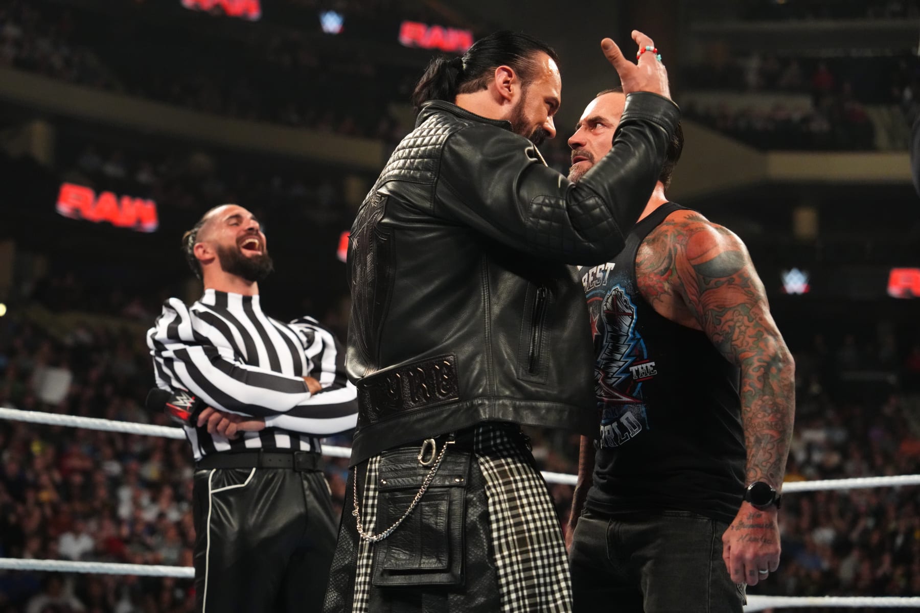 ST PAUL, MINNESOTA - JULY 29: Drew McIntyre (C) faces off in the ring with CM Punk as Seth Rollins (L) laughs during WWE's Monday Night RAW at Xcel Energy Center on July 29, 2024 in St Paul, Minnesota.  (Photo by WWE/Getty Images)