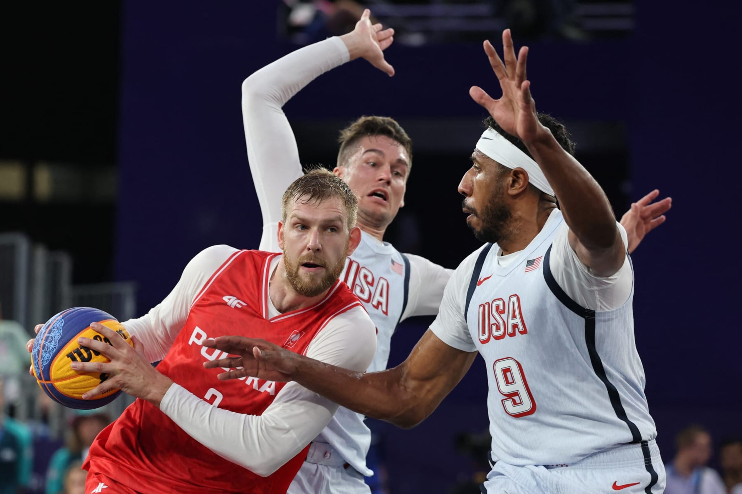 Poland's #03 Michal Sokolowski (L) fights for the ball with US' #05 Jimmer Fredette (C) and US' #09 Kareem Maddox in the men's pool round 3x3 basketball game between the USA and Poland during the Paris 2024 Olympic Games at La Concorde in Paris on July 31, 2024. (Photo by David GRAY / AFP) (Photo by DAVID GRAY/AFP via Getty Images)