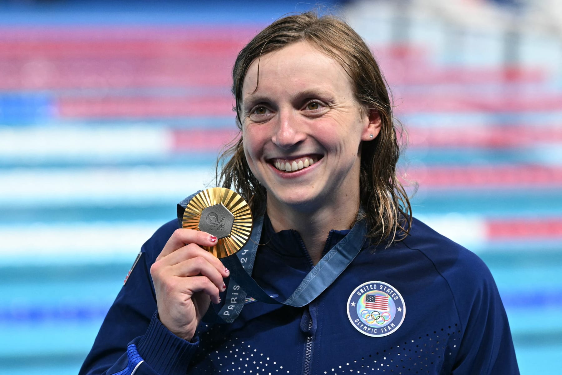 Gold medallist US' Katie Ledecky celebrates during the podium ceremony of the women's 1500m freestyle swimming event during the Paris 2024 Olympic Games at the Paris La Defense Arena in Nanterre, west of Paris, on July 31, 2024. (Photo by Oli SCARFF / AFP) (Photo by OLI SCARFF/AFP via Getty Images)