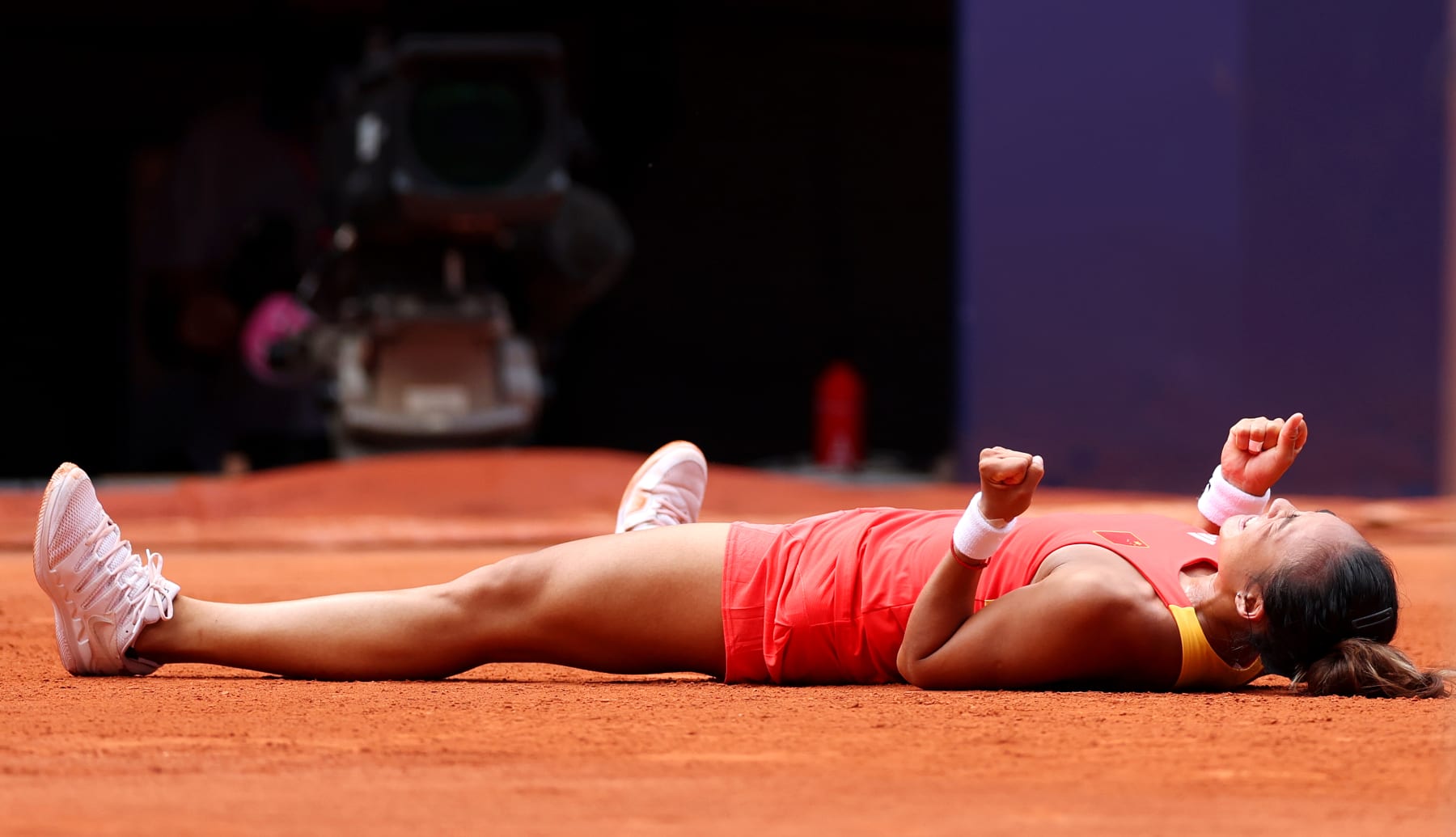 PARIS, FRANCE - AUGUST 01: Qinwen Zheng of Team People's Republic of China celebrates victory against Iga Swiatek of Team Poland during the Women's Singles Semi-final match on day six of the Olympic Games Paris 2024 at Roland Garros on August 01, 2024 in Paris, France. (Photo by Matthew Stockman/Getty Images)