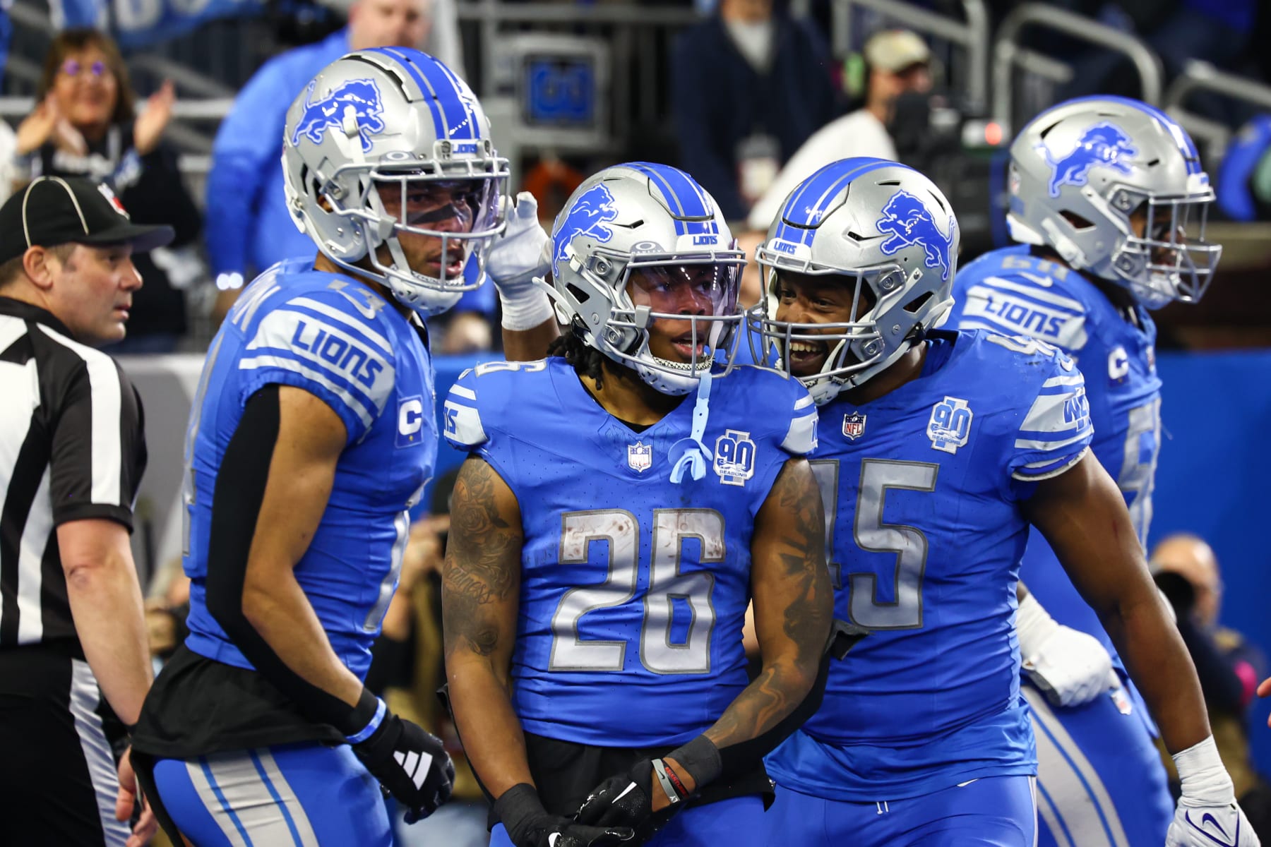 DETROIT, MI - JANUARY 21: Detroit Lions running back Jahmyr Gibbs (26) is congratulated by Detroit Lions fullback Jason Cabinda (45) and Detroit Lions wide receiver Amon-Ra St. Brown (14) after scoring a touchdown on a running play during an NFL NFC Divisional playoff football game between the Tampa Bay Buccaneers and the Detroit Lions on January 21, 2024 at Ford Field in Detroit, Michigan. (Photo by Scott W. Grau/Icon Sportswire via Getty Images)