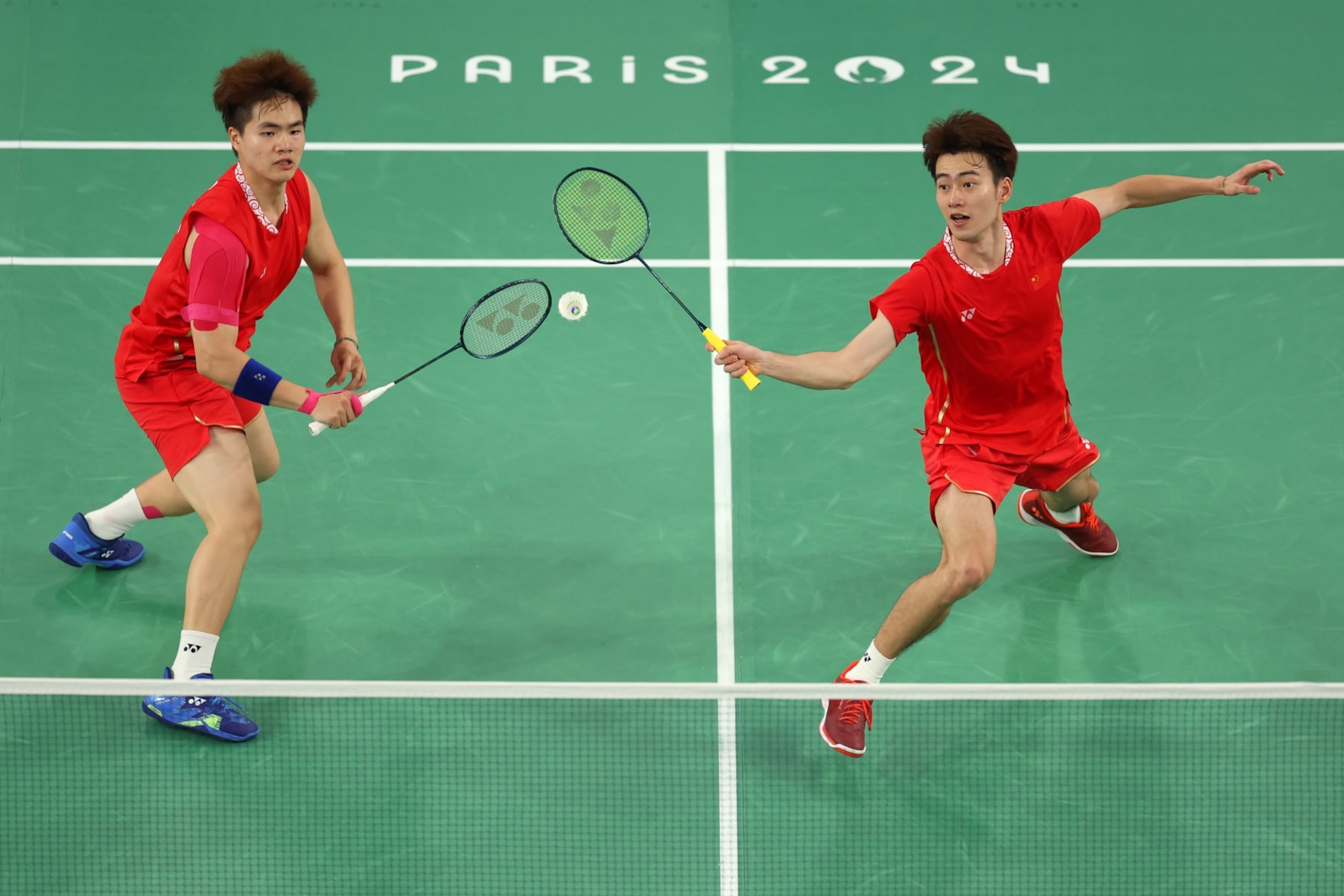 PARIS, FRANCE - AUGUST 02: Wang Chang and Liang Wei Keng of Team China compete for the shuttlecock during the Men’s Doubles Semifinal match between Team People's Republic of China and Team Malaysia on day seven of the Olympic Games Paris 2024 at Porte de La Chapelle Arena on August 02, 2024 in Paris, France. (Photo by Julian Finney/Getty Images)