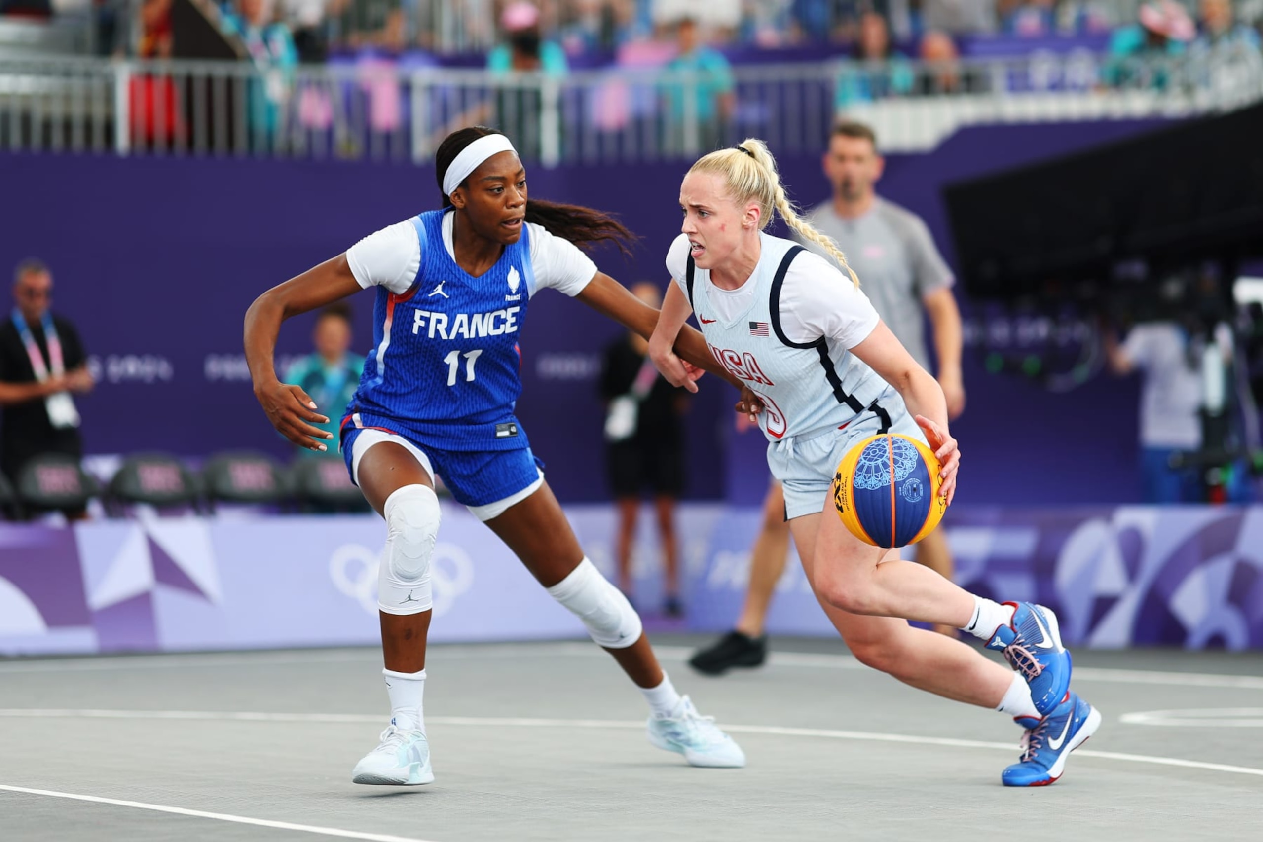 PARIS, FRANCE - AUGUST 02: Hailey van Lith #9 of Team United States dribbles the ball against Myriam Djekoundade #11 of Team France during the Women's 3x3 Basketball Pool Round match between Team Australia and Team Spain on day seven of the Olympic Games Paris 2024 at Esplanade Des Invalides on August 02, 2024 in Paris, France. (Photo by Lintao Zhang/Getty Images)