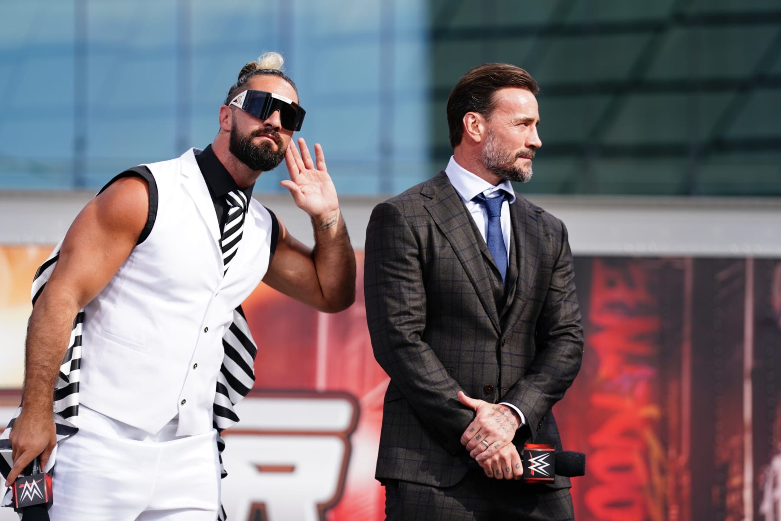 CLEVELAND, OHIO - AUGUST 2: Seth Rollins and CM Punk listen to the crowd during the WWE SummerSlam Kickoff at Rocket Mortgage FieldHouse on August 2, 2024 in Cleveland, Ohio. (Photo by WWE/Getty Images)