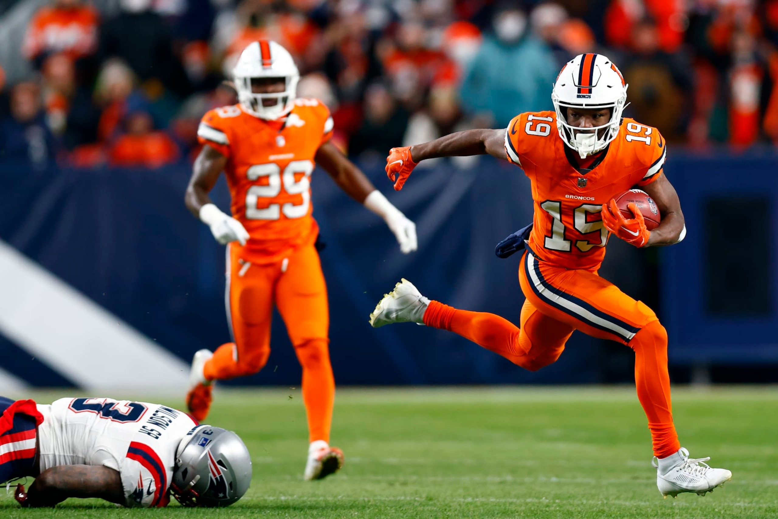 DENVER, COLORADO - DECEMBER 24: Wide receiver Marvin Mims Jr. #19 of the Denver Broncos carries the ball on a punt return as linebacker Mack Wilson Sr. #3 of the New England Patriots defends during the 1st quarter of the game at Empower Field At Mile High on December 24, 2023 in Denver, Colorado. (Photo by Justin Edmonds/Getty Images) DENVER, COLORADO - DECEMBER 24: Wide receiver Marvin Mims Jr. #19 of the Denver Broncos carries the ball on a punt return as linebacker Mack Wilson Sr. #3 of the New England Patriots defends during the 1st quarter of the game at Empower Field At Mile High on December 24, 2023 in Denver, Colorado. (Photo by Justin Edmonds/Getty Images)