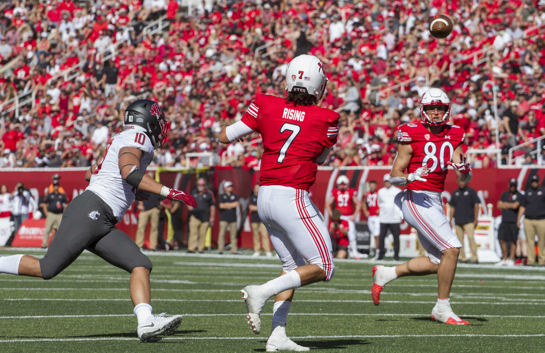 SALT LAKE CITY, UT -  SEPTEMBER 25 : Cam Rising #7  of the Utah Utes throws a pass to Brant Kuithe #80 under pressure from Ron Stone Jr., #10 of the Washington State Cougars  during their game September 25, 2021 at Rice Eccles Stadium in Salt Lake City, Utah. (Photo by Chris Gardner/Getty Images)