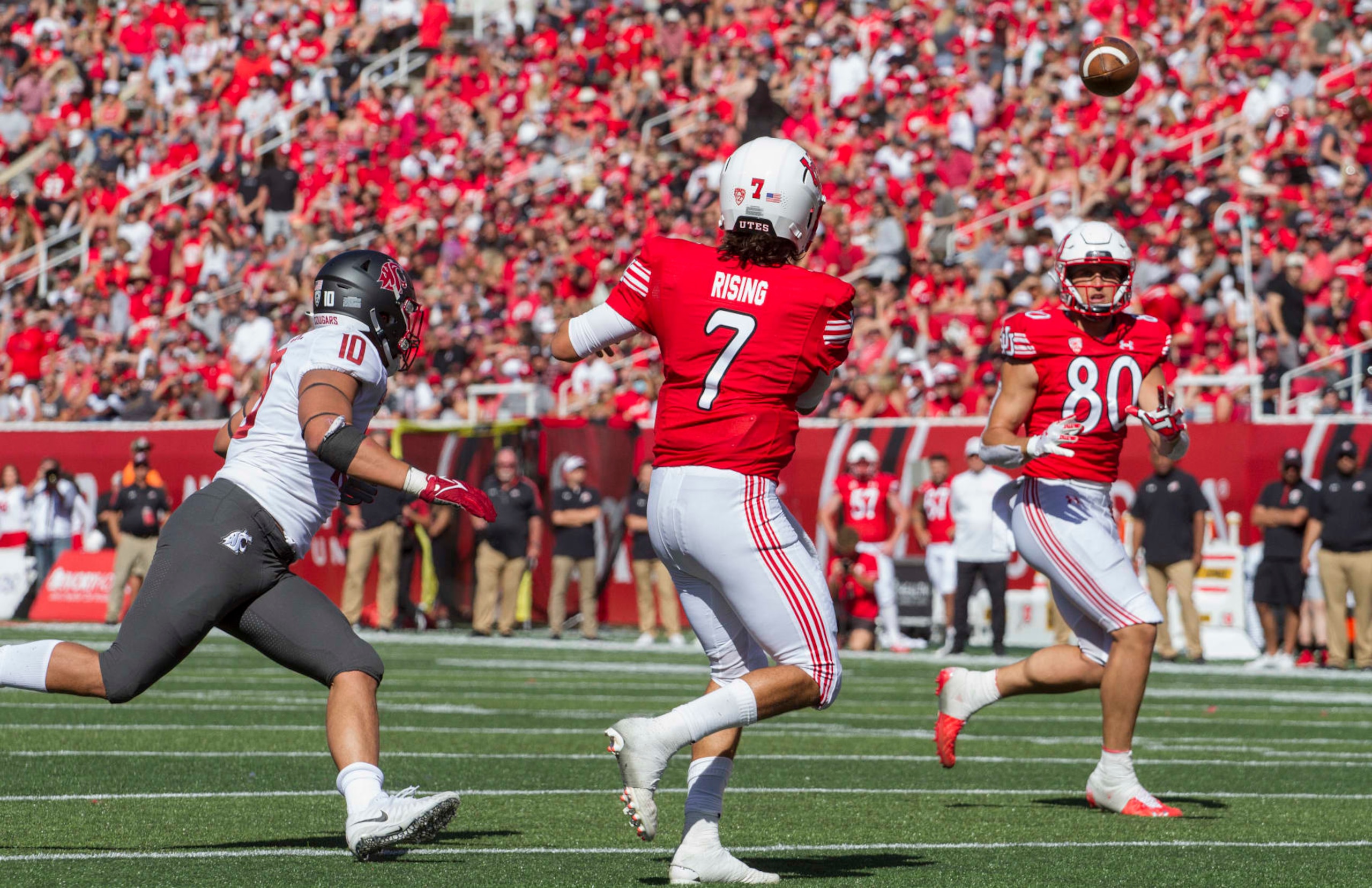 SALT LAKE CITY, UT -  SEPTEMBER 25 : Cam Rising #7  of the Utah Utes throws a pass to Brant Kuithe #80 under pressure from Ron Stone Jr., #10 of the Washington State Cougars  during their game September 25, 2021 at Rice Eccles Stadium in Salt Lake City, Utah. (Photo by Chris Gardner/Getty Images)