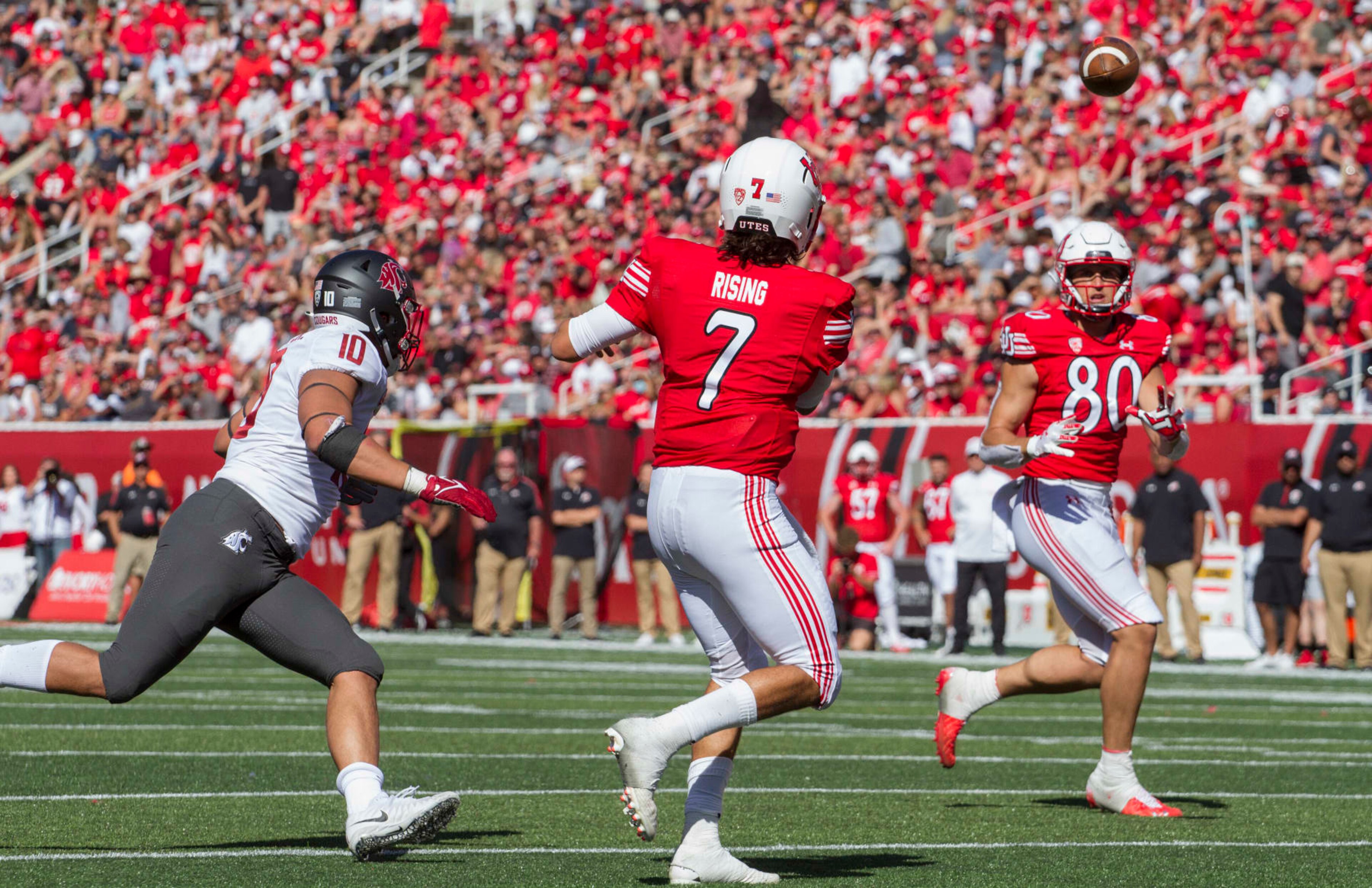 SALT LAKE CITY, UT -  SEPTEMBER 25 : Cam Rising #7  of the Utah Utes throws a pass to Brant Kuithe #80 under pressure from Ron Stone Jr., #10 of the Washington State Cougars  during their game September 25, 2021 at Rice Eccles Stadium in Salt Lake City, Utah. (Photo by Chris Gardner/Getty Images)