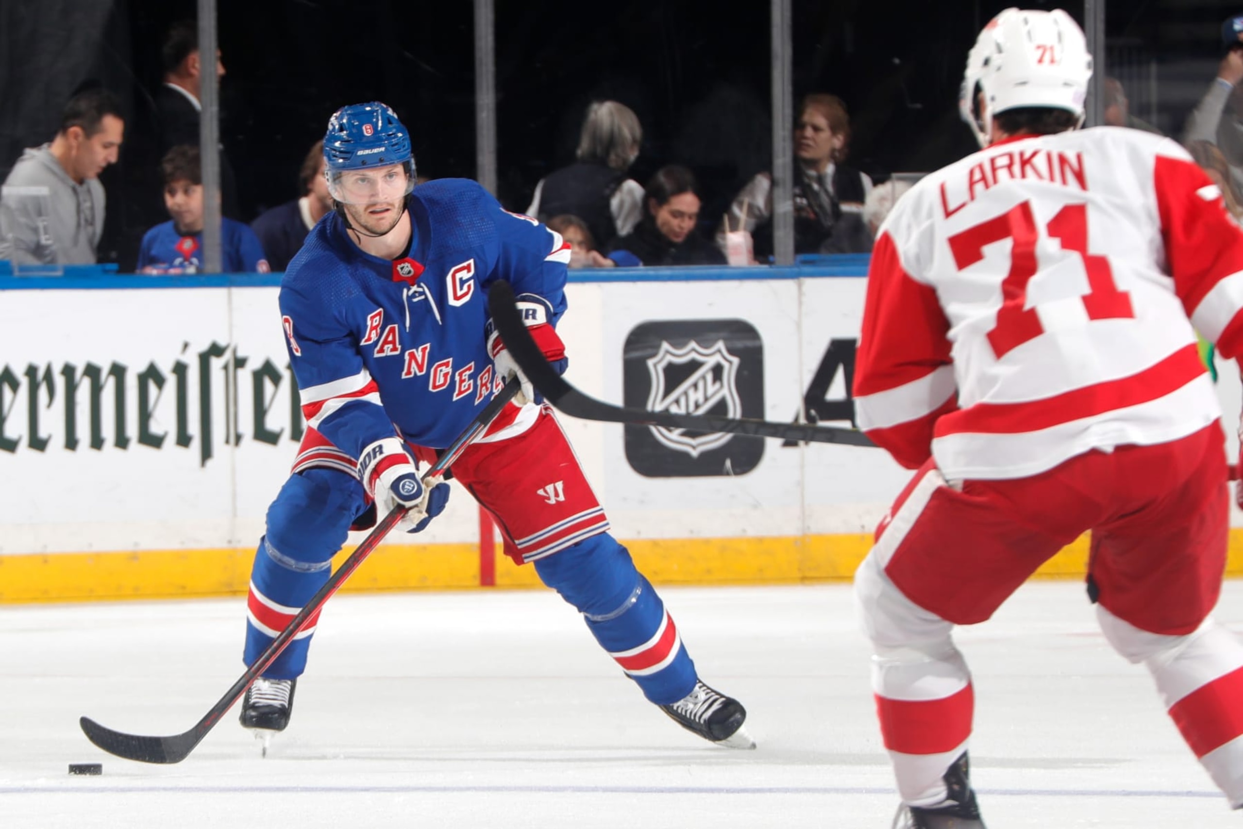 NEW YORK, NEW YORK - NOVEMBER 06:  Jacob Trouba #8 of the New York Rangers skates with the puck against Dylan Larkin #71 of the Detroit Red Wings at Madison Square Garden on November 6, 2022 in New York City. (Photo by Jared Silber/NHLI via Getty Images)