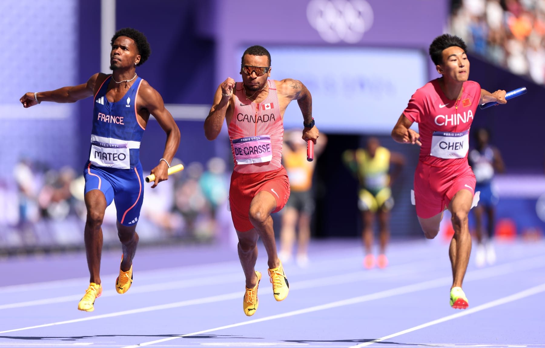 PARIS, FRANCE - AUGUST 08: Pablo Mateo of Team France, Andre de Grasse of Team Canada and Jiapeng Chen of Team People's Republic of China compete in the Men's 4 x 100m Relay on day thirteen of the Olympic Games Paris 2024 at Stade de France on August 08, 2024 in Paris, France. (Photo by Hannah Peters/Getty Images)