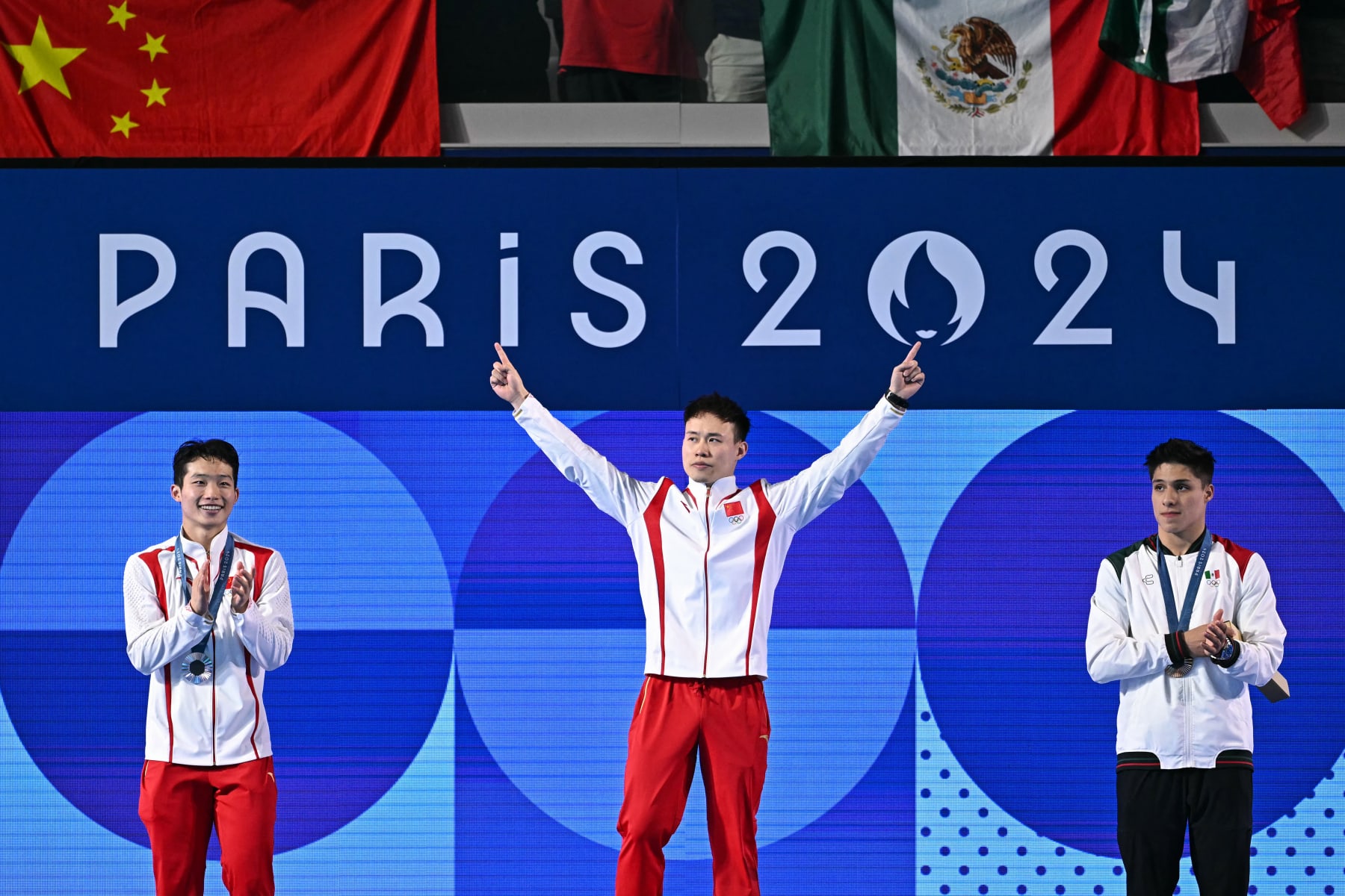 (L-R) Silver medallist China's Wang Zongyuan, gold medallist China's Xie Siyi and bronze medallist Mexico's Osmar Olvera Ibarra stand on the podium after the men's 3m springboard diving final during the Paris 2024 Olympic Games at the Aquatics Centre in Saint-Denis, north of Paris, on August 8, 2024. (Photo by Manan VATSYAYANA / AFP) (Photo by MANAN VATSYAYANA/AFP via Getty Images)