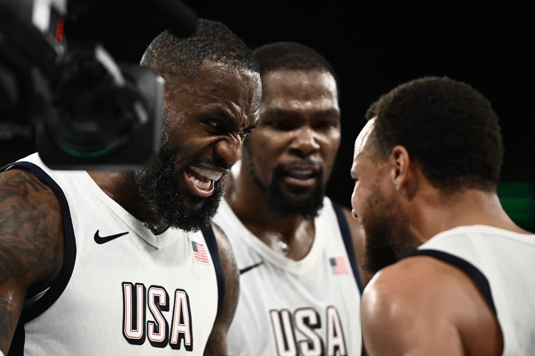 USA's #06 LeBron James (L) celebrates with USA's #04 Stephen Curry at the end of the men's semifinal basketball match between USA and Serbia during the Paris 2024 Olympic Games at the Bercy  Arena in Paris on August 8, 2024. (Photo by Aris MESSINIS / AFP) (Photo by ARIS MESSINIS/AFP via Getty Images)