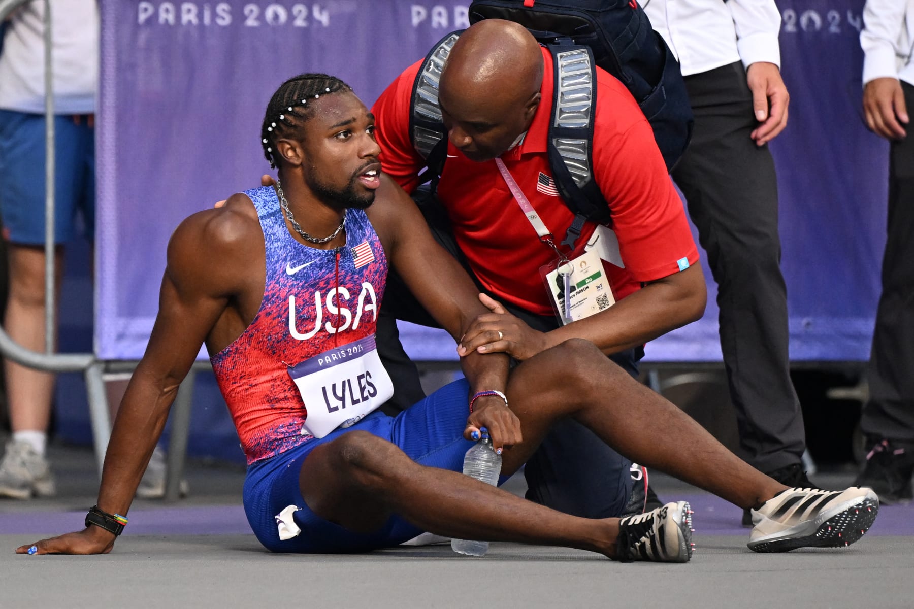 Bronze medallist US' Noah Lyles (C) receives medical attention after competing in the men's 200m final of the athletics event at the Paris 2024 Olympic Games at Stade de France in Saint-Denis, north of Paris, on August 8, 2024. (Photo by Kirill KUDRYAVTSEV / AFP) (Photo by KIRILL KUDRYAVTSEV/AFP via Getty Images)
