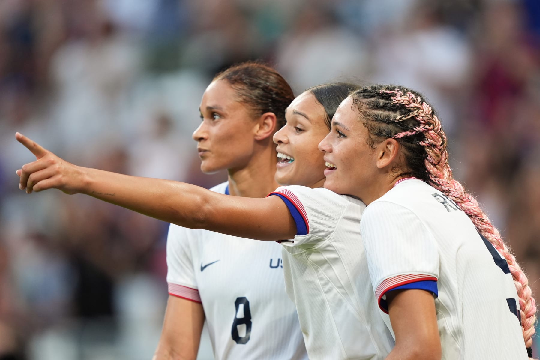 LYON, FRANCE - AUGUST 06: Sophia Smith #11 of the United States celebrates with Lynn Williams #8 and Trinity Rodman #5 after defeating Germany during the Women's semifinal match during the Olympic Games Paris 2024 at Stade de Lyon on August 06, 2024 in Lyon, France. (Photo by Andrea Vilchez/ISI/Getty Images)