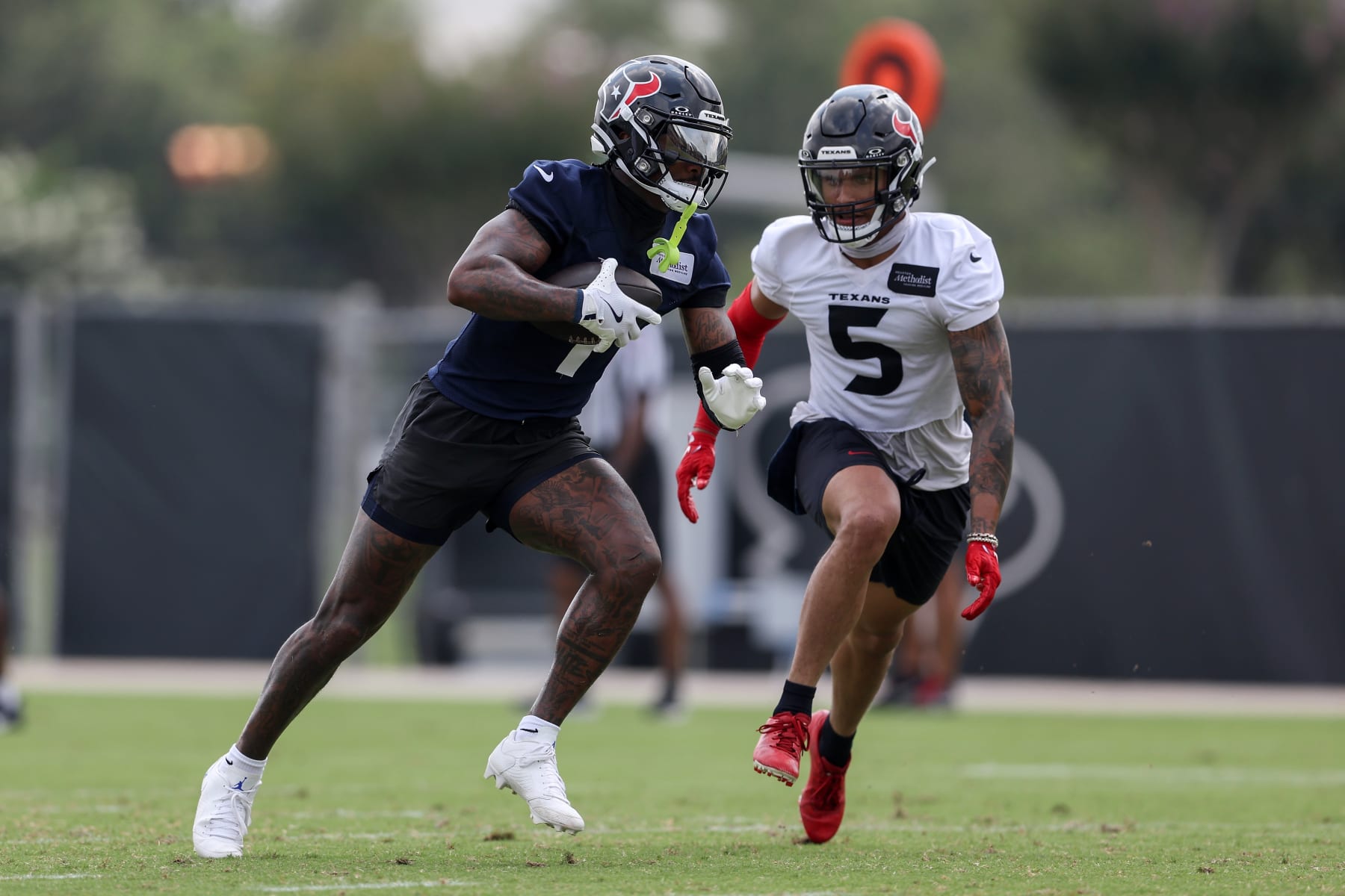 HOUSTON, TEXAS - JUNE 04: Stefon Diggs #1 of the Houston Texans runs after a catch while defended by Jalen Pitre #5 during Mandatory Minicamp at Houston Methodist Training Center on June 04, 2024 in Houston, Texas. (Photo by Tim Warner/Getty Images)