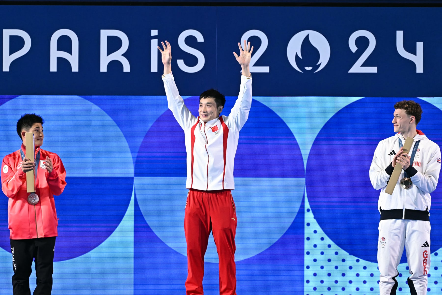 (L-R) Silver medallist Japan's Rikuto Tamai, gold medallist China's Cao Yuan and bronze medallist Britain's Noah Williams stand on the podium after the men's 10m platform diving final during the Paris 2024 Olympic Games at the Aquatics Centre in Saint-Denis, north of Paris, on August 10, 2024. (Photo by Manan VATSYAYANA / AFP) (Photo by MANAN VATSYAYANA/AFP via Getty Images)