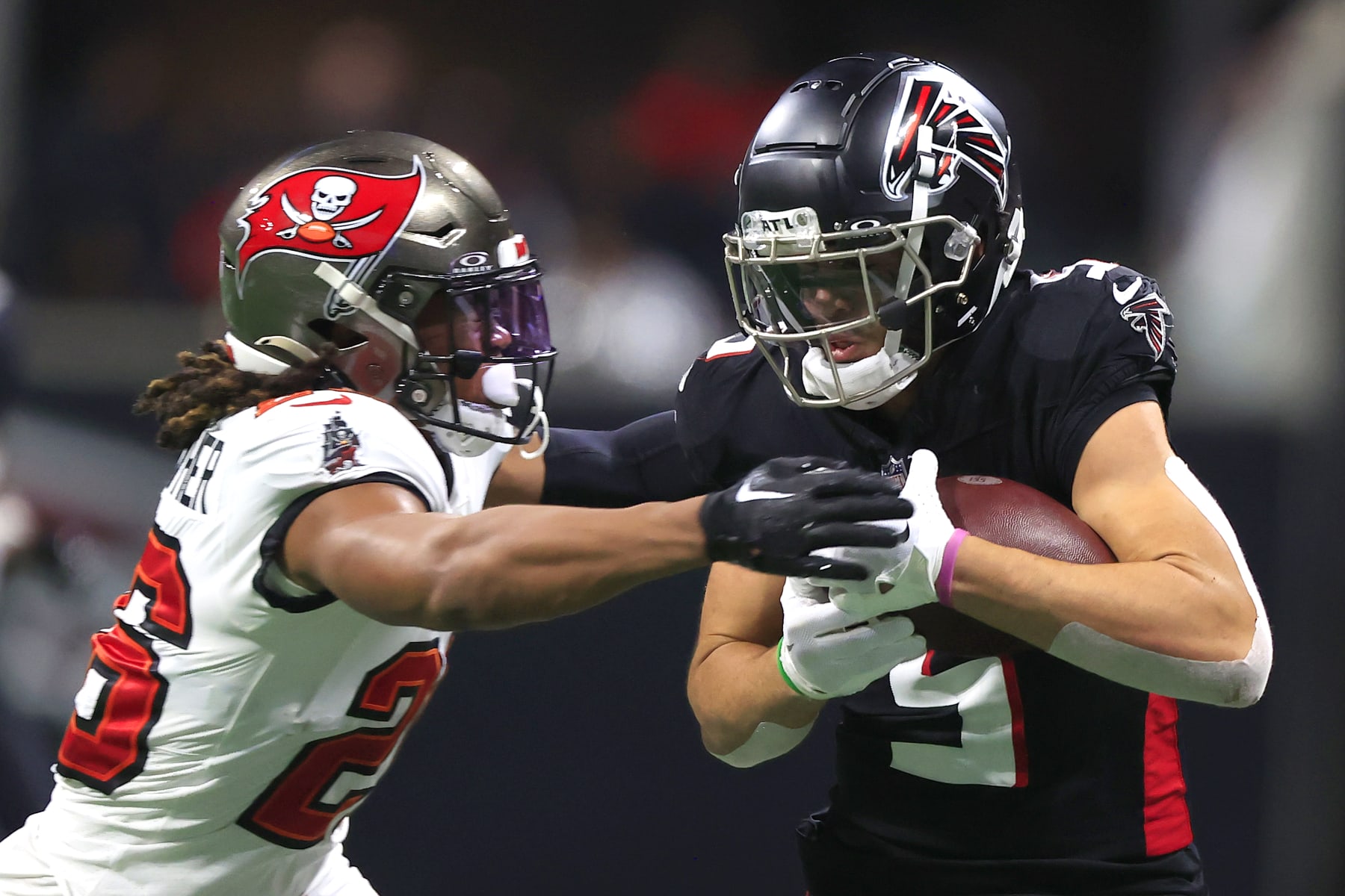ATLANTA, GA - DECEMBER 10: Tampa Bay Buccaneers safety Kaevon Merriweather (26) attempts to strip the football from Atlanta Falcons wide receiver Drake London (5) during the Sunday afternoon NFL football game between  division rivals Atlanta Falcons and the Tampa Bay Buccaneers on December 10, 2023 at the Mercedes-Benz Stadium in Atlanta, Georgia.  (Photo by David J. Griffin/Icon Sportswire via Getty Images)