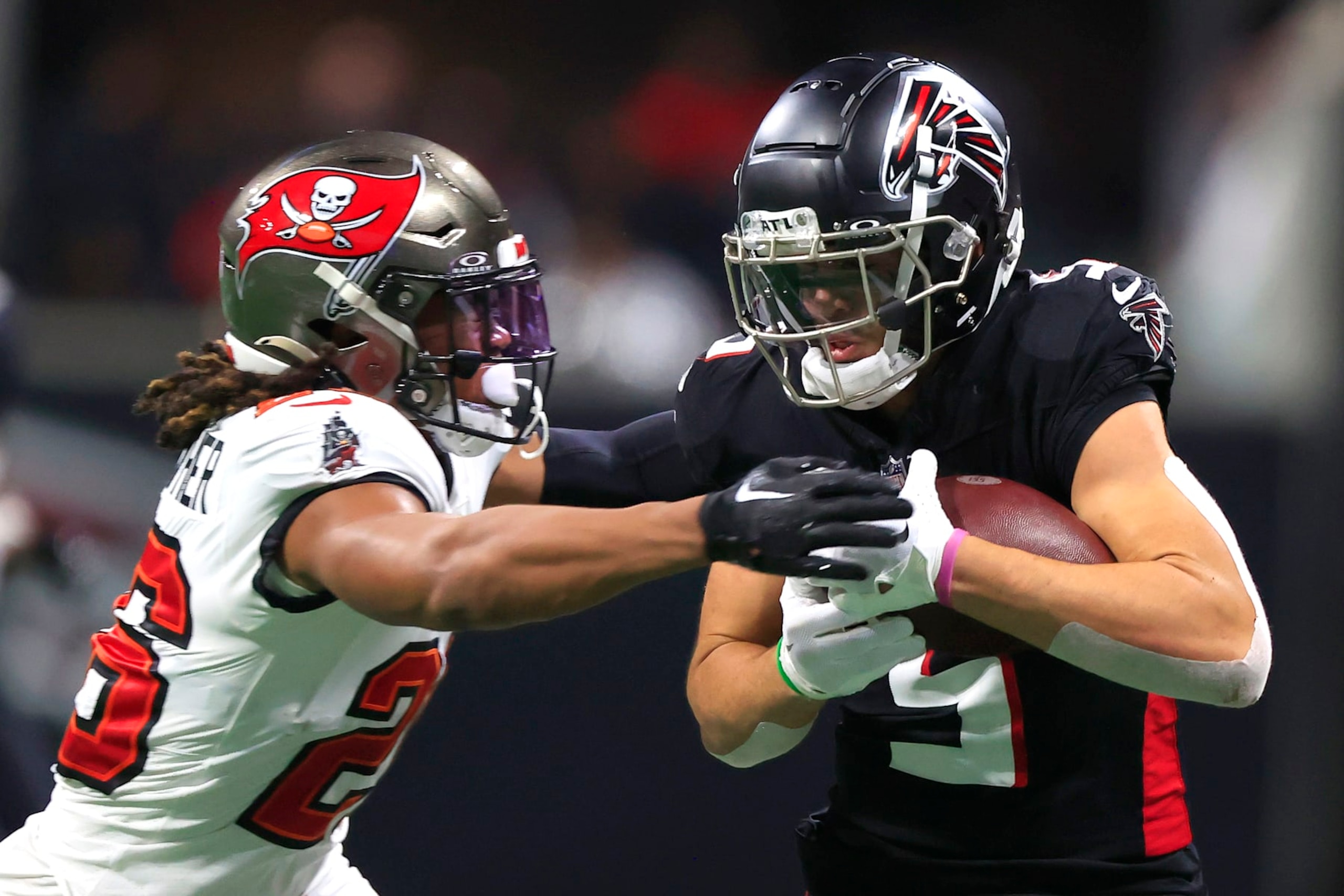 ATLANTA, GA - DECEMBER 10: Tampa Bay Buccaneers safety Kaevon Merriweather (26) attempts to strip the football from Atlanta Falcons wide receiver Drake London (5) during the Sunday afternoon NFL football game between  division rivals Atlanta Falcons and the Tampa Bay Buccaneers on December 10, 2023 at the Mercedes-Benz Stadium in Atlanta, Georgia.  (Photo by David J. Griffin/Icon Sportswire via Getty Images)