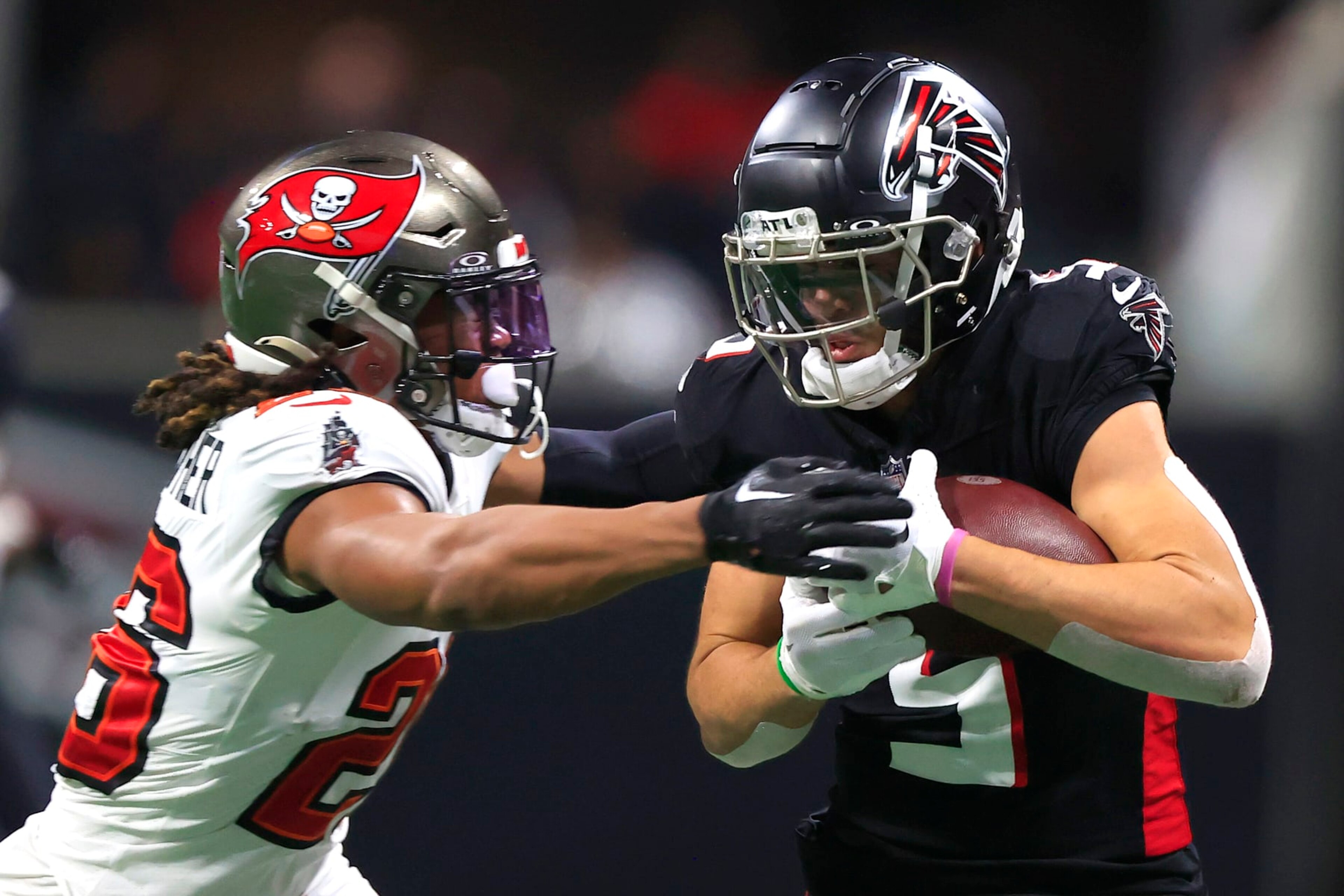 ATLANTA, GA - DECEMBER 10: Tampa Bay Buccaneers safety Kaevon Merriweather (26) attempts to strip the football from Atlanta Falcons wide receiver Drake London (5) during the Sunday afternoon NFL football game between  division rivals Atlanta Falcons and the Tampa Bay Buccaneers on December 10, 2023 at the Mercedes-Benz Stadium in Atlanta, Georgia.  (Photo by David J. Griffin/Icon Sportswire via Getty Images)