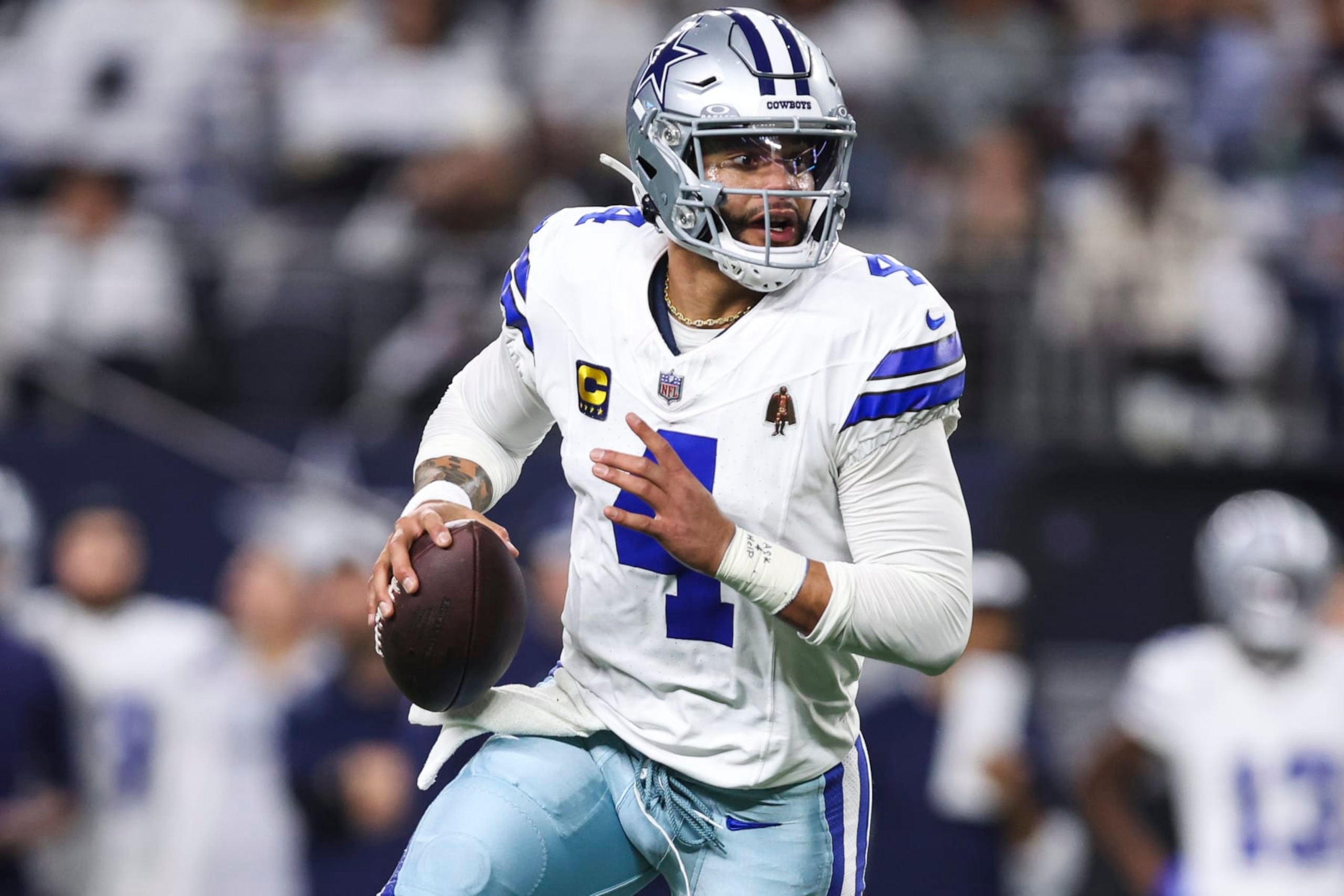 ARLINGTON, TX - JANUARY 14: Dak Prescott #4 of the Dallas Cowboys scrambles out of the pocket during an NFL wild-card playoff football game against the Green Bay Packers at AT&T Stadium on January 14, 2024 in Arlington, Texas. (Photo by Perry Knotts/Getty Images)
