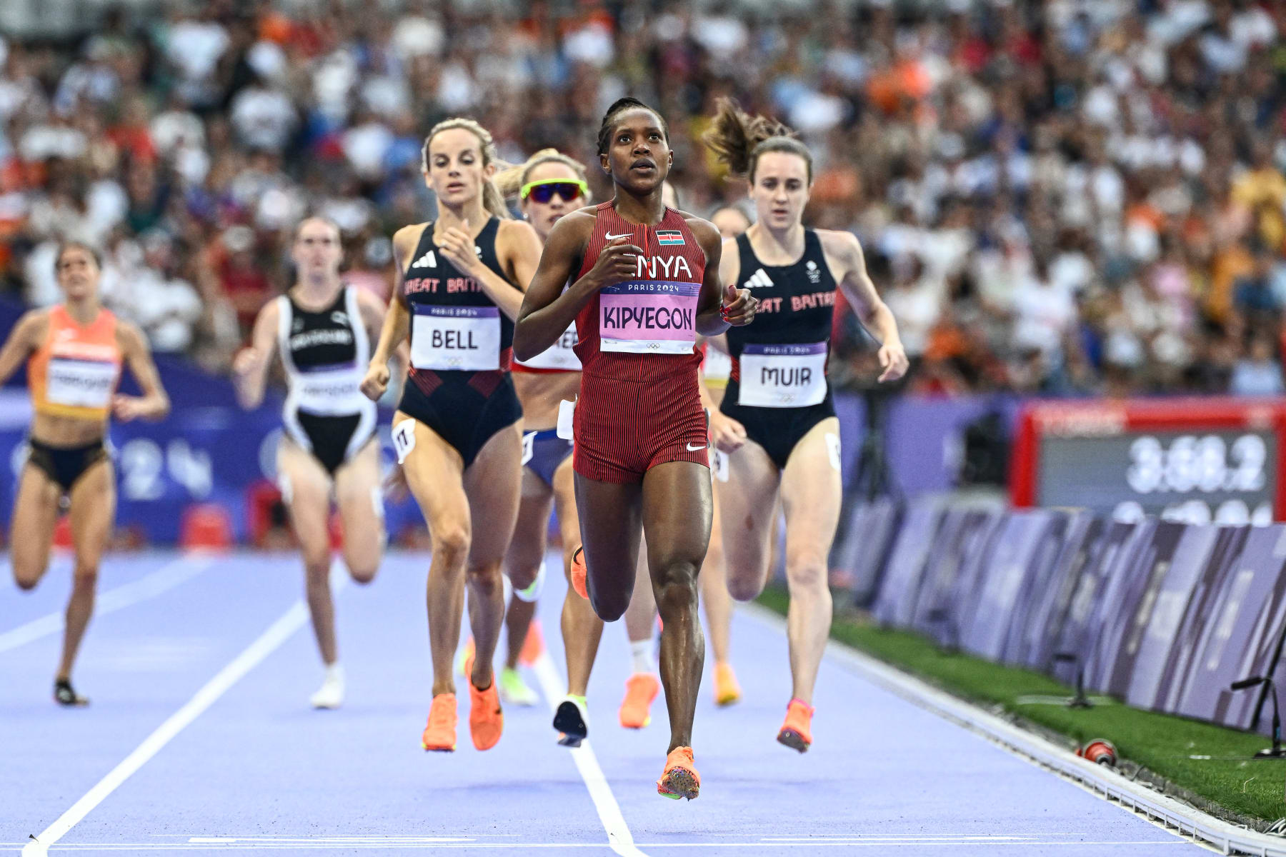 Kenya's Faith Kipyegon crosses the finish line ahead of Britain's Georgia Bell and Britain's Laura Muir in the women's 1500m semi-final of the athletics event at the Paris 2024 Olympic Games at Stade de France in Saint-Denis, north of Paris, on August 8, 2024. (Photo by Jewel SAMAD / AFP) (Photo by JEWEL SAMAD/AFP via Getty Images)