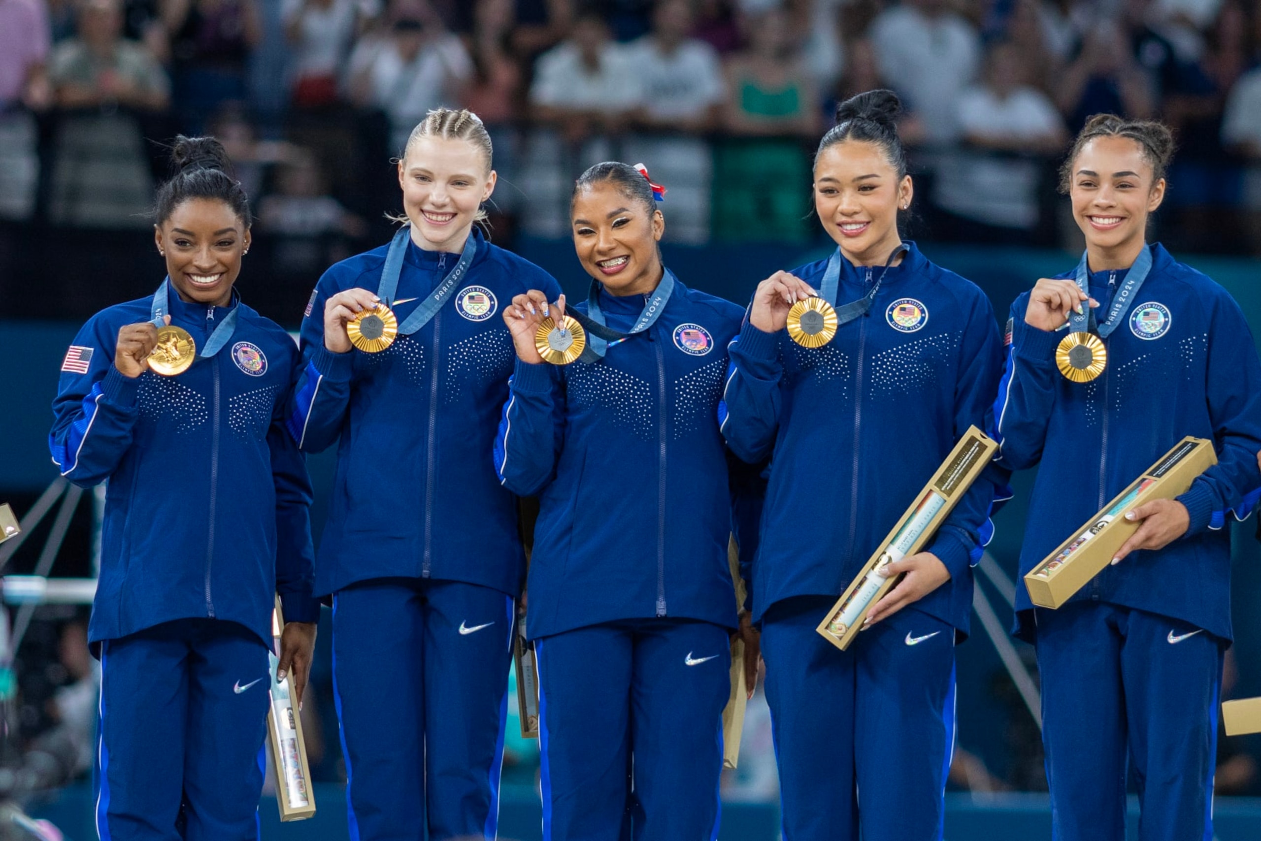 PARIS, FRANCE: JULY 30:  The United States team of Simone Biles, Jade Carey,  Jordan Chiles, Sunisa Lee, and Hezly Rivera on the podium with their gold medals after the team's victory during the Artistic Gymnastics Team Final for Women at the Bercy Arena during the Paris 2024 Summer Olympic Games on July 30th, 2024 in Paris, France. (Photo by Tim Clayton/Corbis via Getty Images)