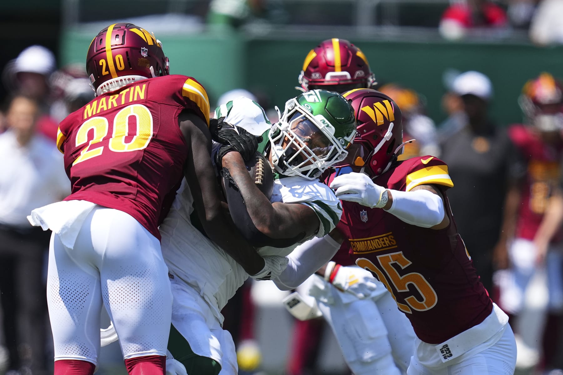 EAST RUTHERFORD, NEW JERSEY - AUGUST 10: Quan Martin #20 of the Washington Commanders tackles Braelon Allen #0 of the New York Jets in the first half of the preseason game against at MetLife Stadium on August 10, 2024 in East Rutherford, New Jersey. (Photo by Mitchell Leff/Getty Images)