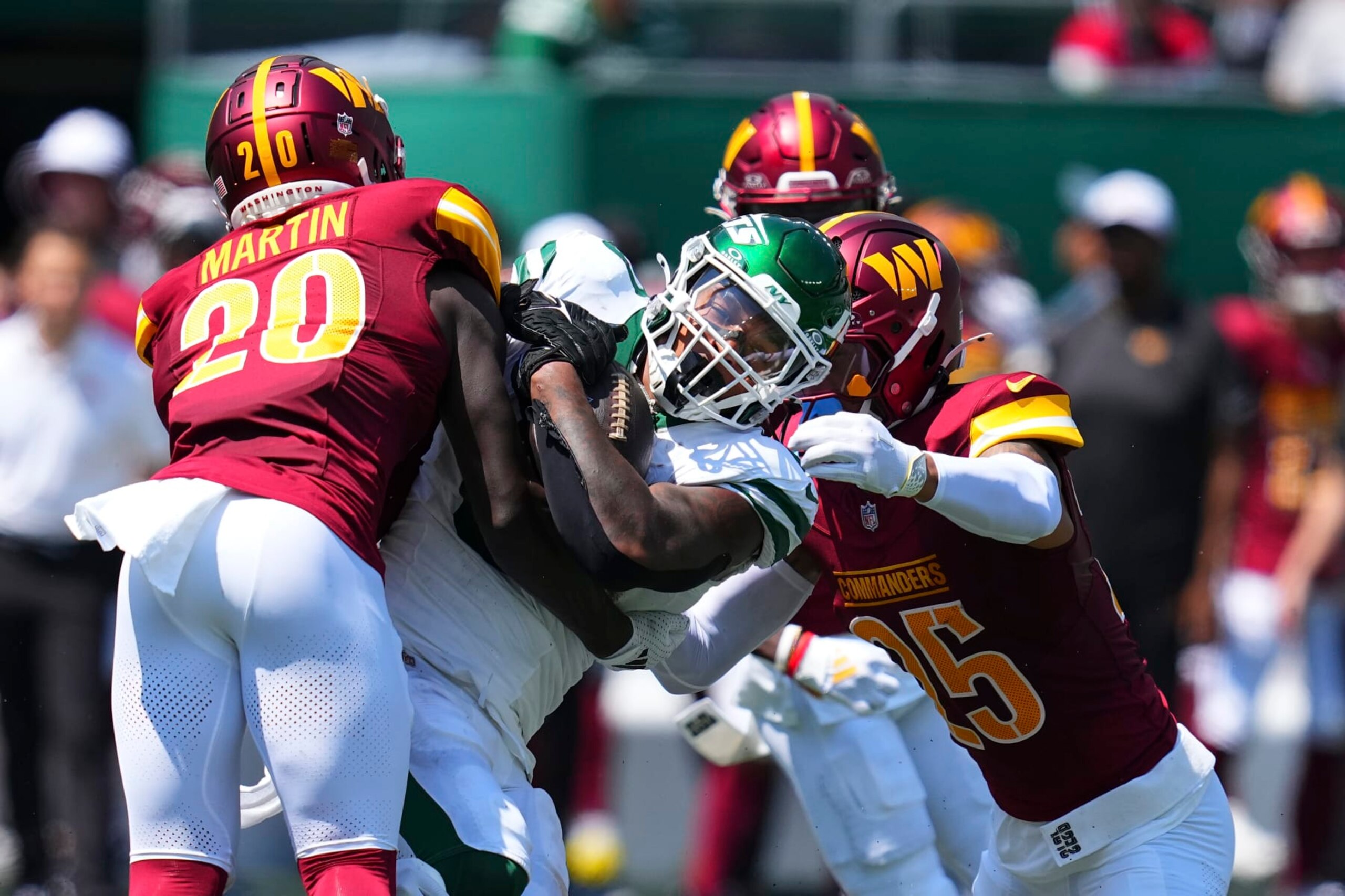 EAST RUTHERFORD, NEW JERSEY - AUGUST 10: Quan Martin #20 of the Washington Commanders tackles Braelon Allen #0 of the New York Jets in the first half of the preseason game against at MetLife Stadium on August 10, 2024 in East Rutherford, New Jersey. (Photo by Mitchell Leff/Getty Images)