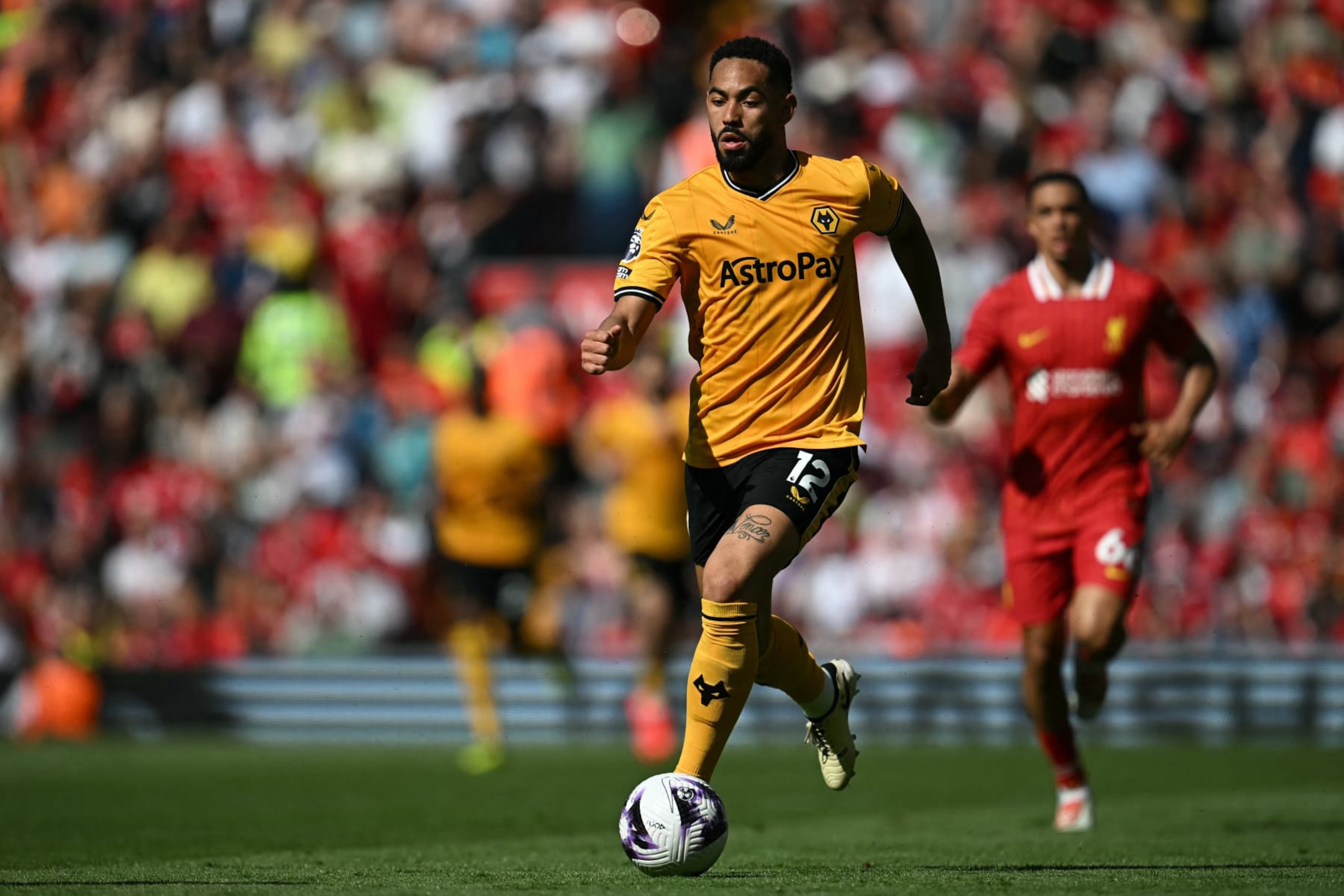Wolverhampton Wanderers' Brazilian striker #12 Matheus Cunha runs with the ball during the English Premier League football match between Liverpool and Wolverhampton Wanderers at Anfield in Liverpool, north west England on May 19, 2024. (Photo by Paul ELLIS / AFP) / RESTRICTED TO EDITORIAL USE. No use with unauthorized audio, video, data, fixture lists, club/league logos or 'live' services. Online in-match use limited to 120 images. An additional 40 images may be used in extra time. No video emulation. Social media in-match use limited to 120 images. An additional 40 images may be used in extra time. No use in betting publications, games or single club/league/player publications. /  (Photo by PAUL ELLIS/AFP via Getty Images)
