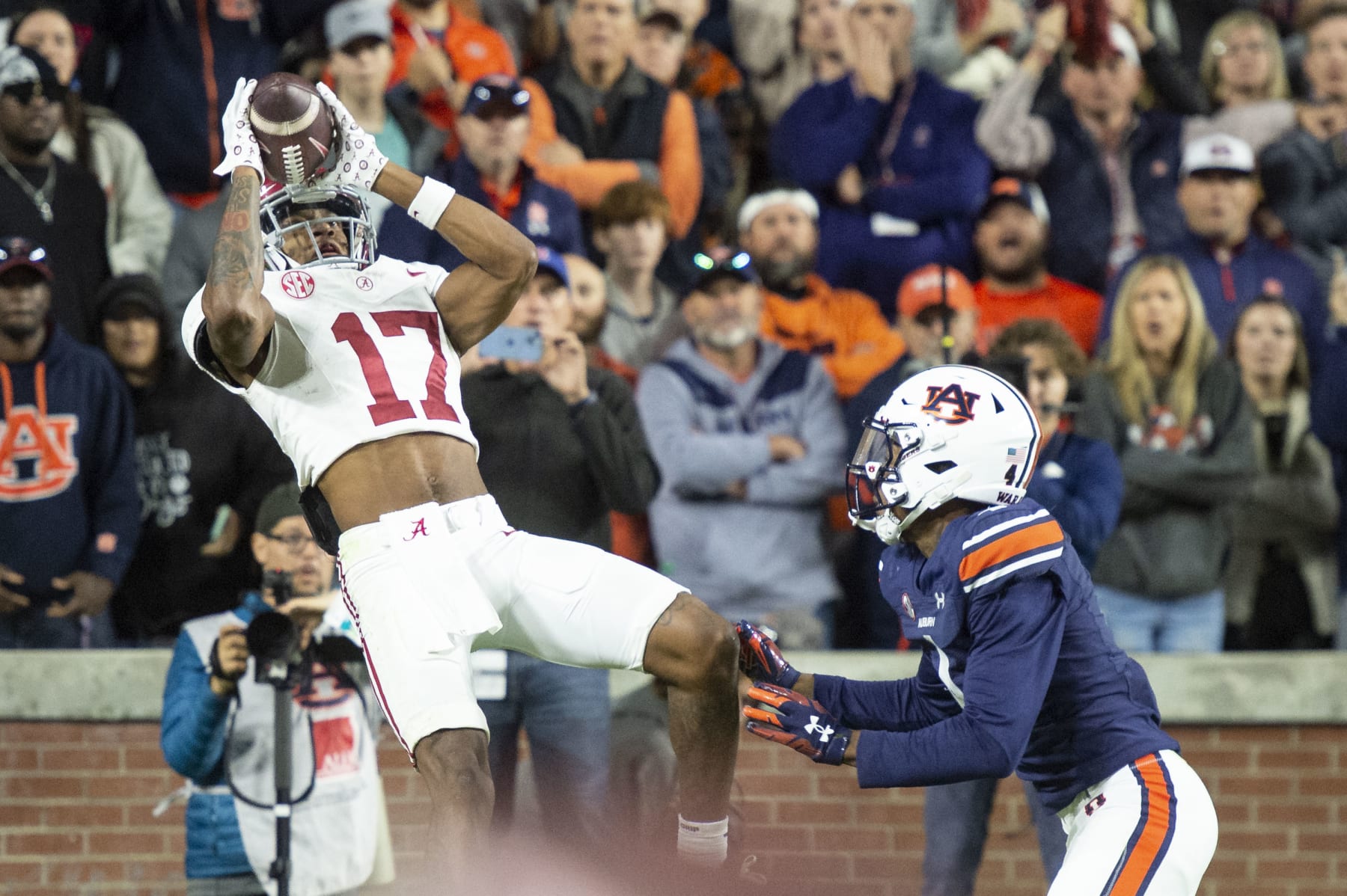 AUBURN, ALABAMA - NOVEMBER 25: Wide receiver Isaiah Bond #17 of the Alabama Crimson Tide catches a pass for a touchdown in front of cornerback D.J. James #4 of the Auburn Tigers during the second half of play at Jordan-Hare Stadium on November 25, 2023 in Auburn, Alabama. (Photo by Michael Chang/Getty Images)