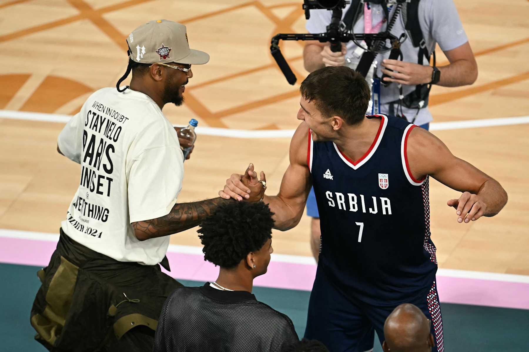 Serbia's #07 Bogdan Bogdanovic shakes hads with US basketball player Carmelo Anthony (L) after the men's Bronze Medal basketball match between Germany and Serbia during the Paris 2024 Olympic Games at the Bercy  Arena in Paris on August 10, 2024. (Photo by Paul ELLIS / AFP) (Photo by PAUL ELLIS/AFP via Getty Images)