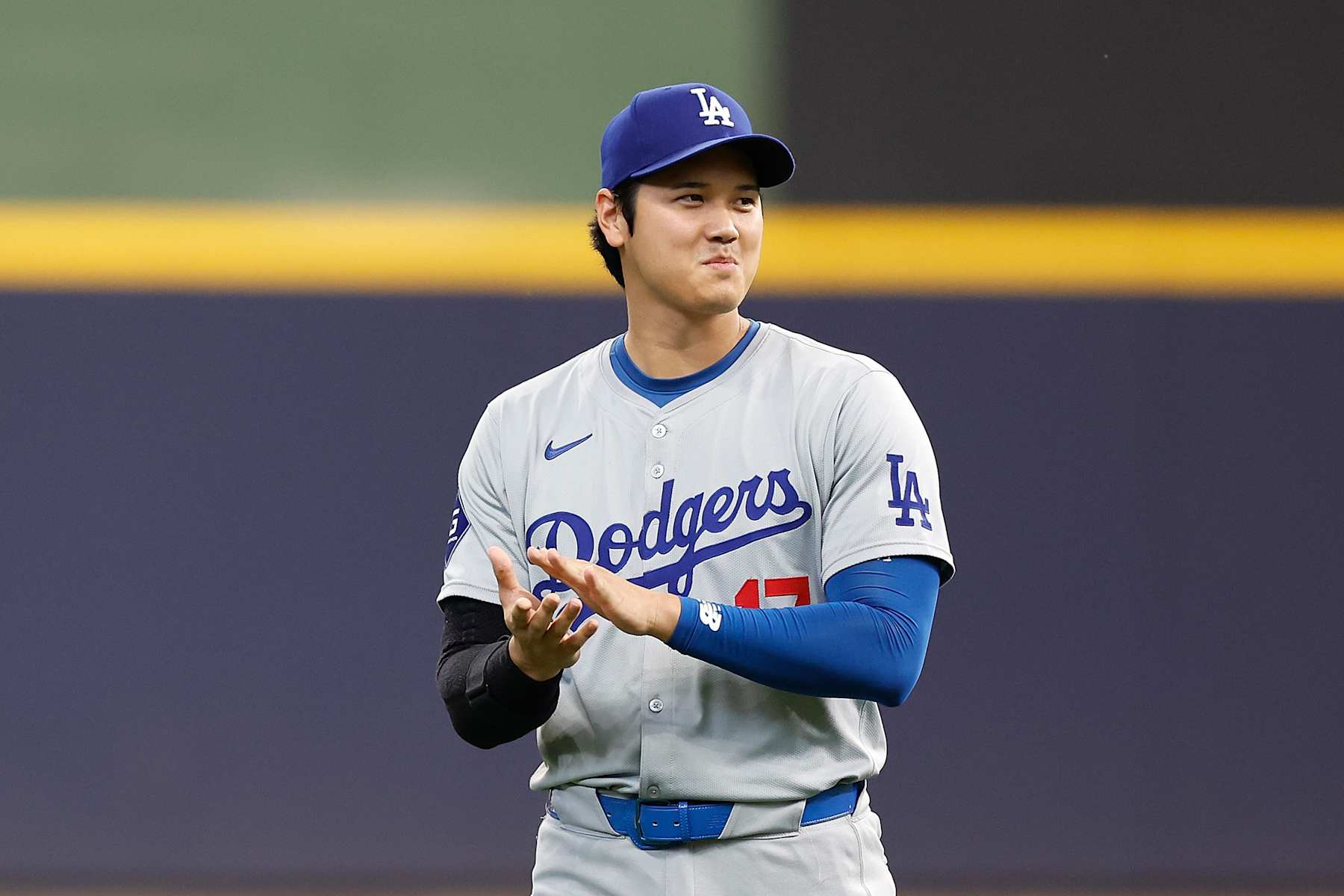 MILWAUKEE, WISCONSIN - AUGUST 15: Shohei Ohtani #17 of the Los Angeles Dodgers claps while watching a lady 102 years old throw a ceremony pitch before game \amb at American Family Field on August 15, 2024 in Milwaukee, Wisconsin. (Photo by John Fisher/Getty Images)