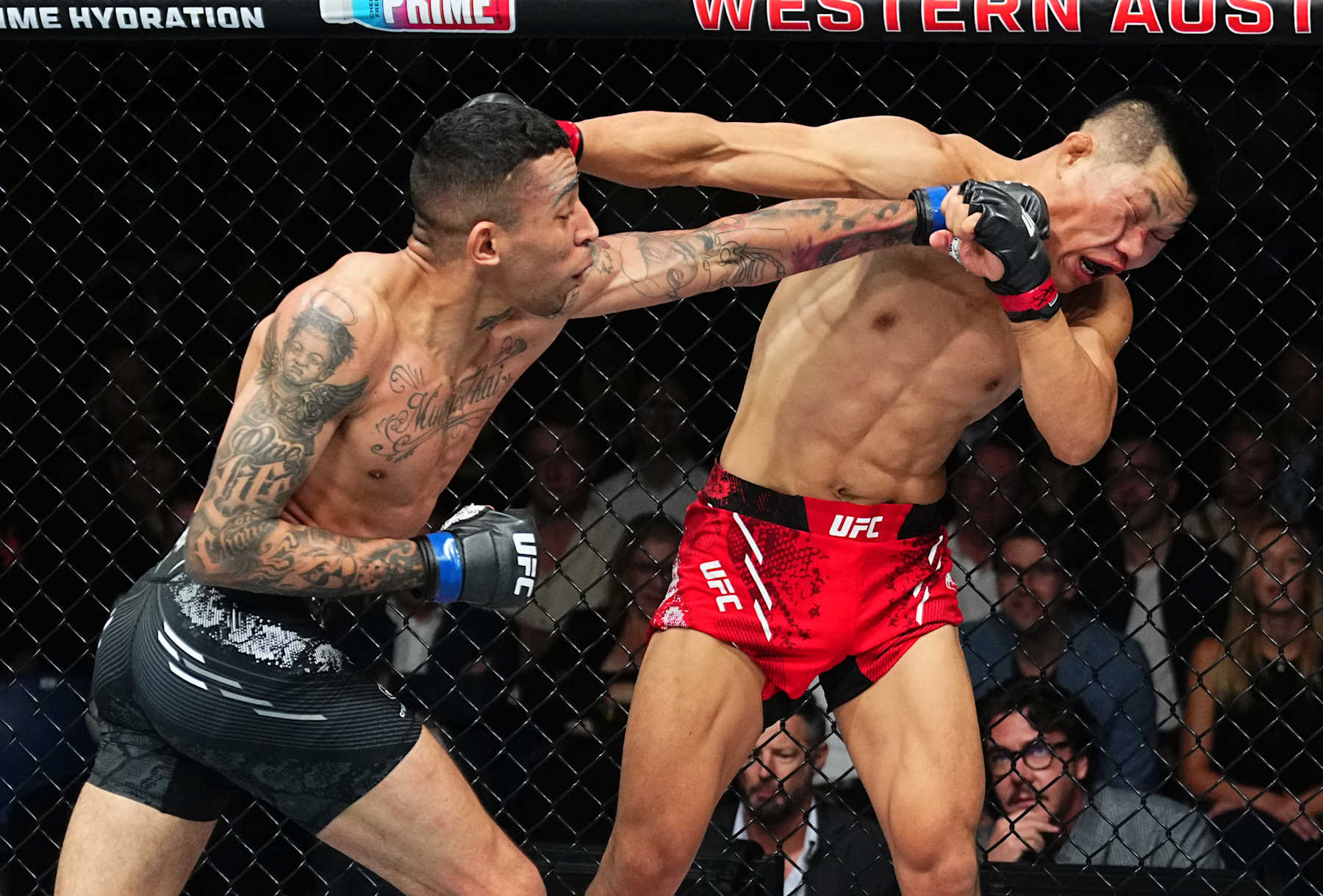 PERTH, AUSTRALIA - AUGUST 18: (L-R) Carlos Prates of Brazil punches Li Jingliang of China in a welterweight fight during the UFC 305 event at RAC Arena on August 18, 2024 in Perth, Australia. (Photo by Jeff Bottari/Zuffa LLC)