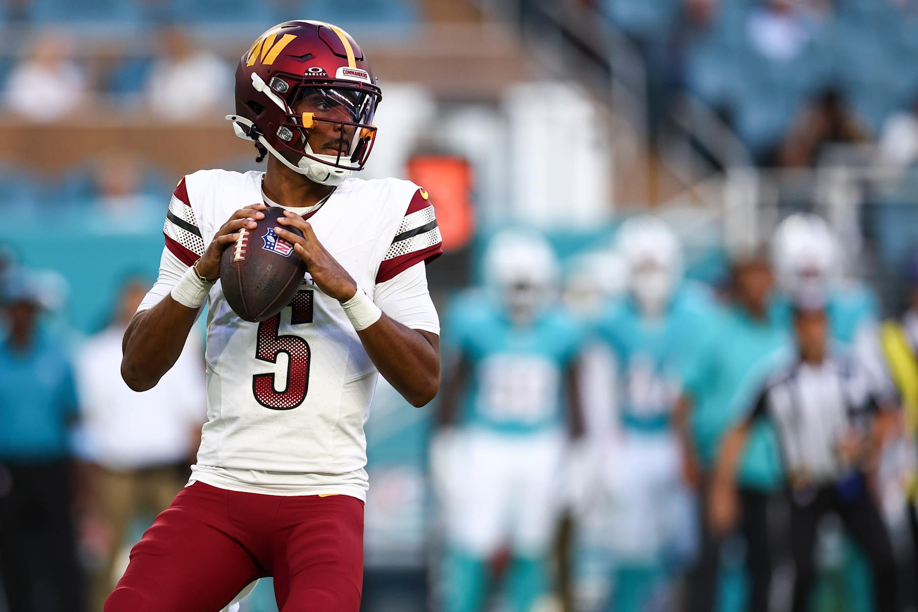 MIAMI GARDENS, FL - AUGUST 17: Jayden Daniels #5 of the Washington Commanders drops back to pass during the first quarter of an NFL preseason football game against the Miami Dolphins at Hard Rock Stadium on August 17, 2024 in Miami Gardens, Florida. (Photo by Kevin Sabitus/Getty Images)