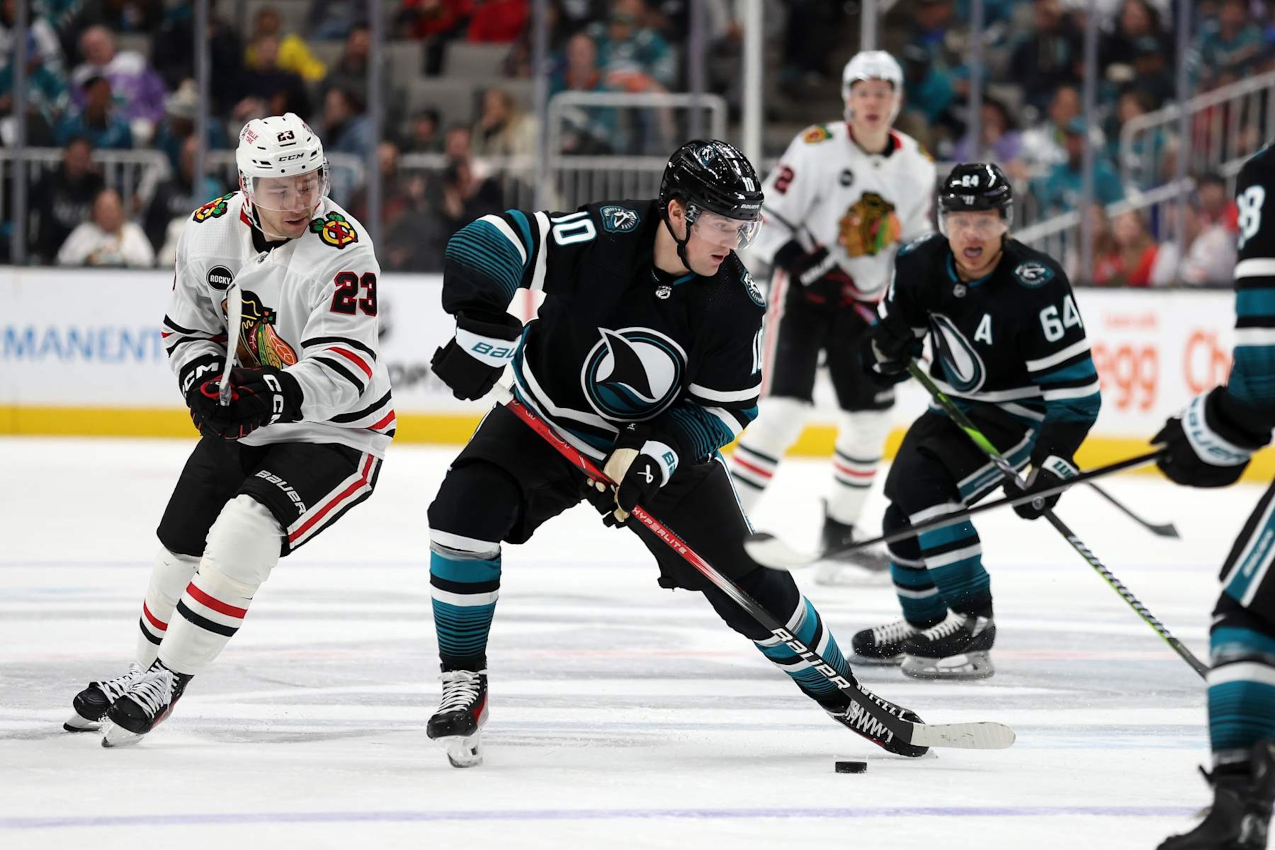 SAN JOSE, CALIFORNIA - MARCH 23: Klim Kostin #10 of the San Jose Sharks controls the puck in front of Philipp Kurashev #23 of the Chicago Blackhawks at SAP Center on March 23, 2024 in San Jose, California. (Photo by Ezra Shaw/Getty Images)